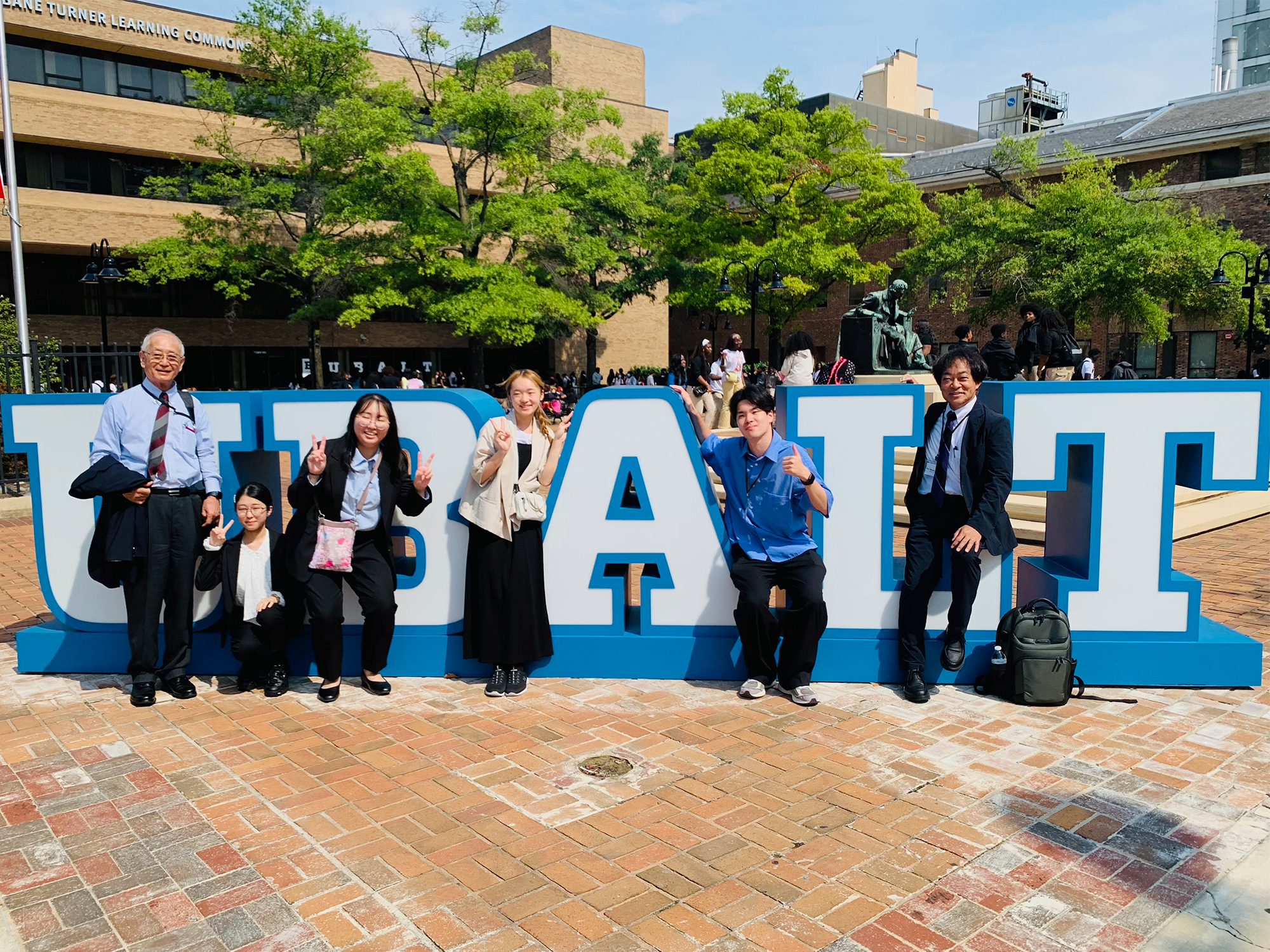 Visitors from Ehime University pose with the UBalt campus sign
