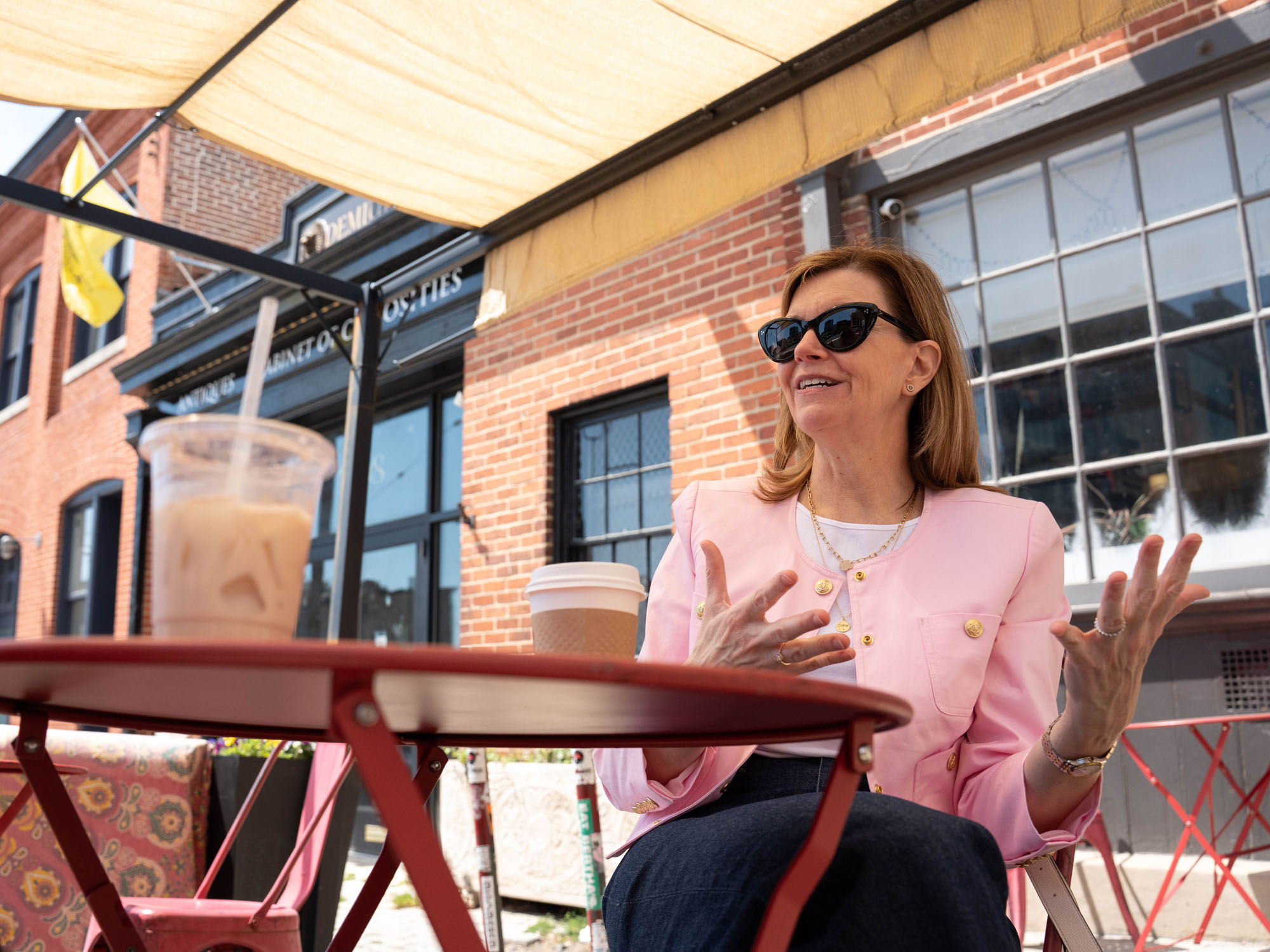 Dionne Koller, a law professor, talks with her hands while sitting at an outdoor cafe table.