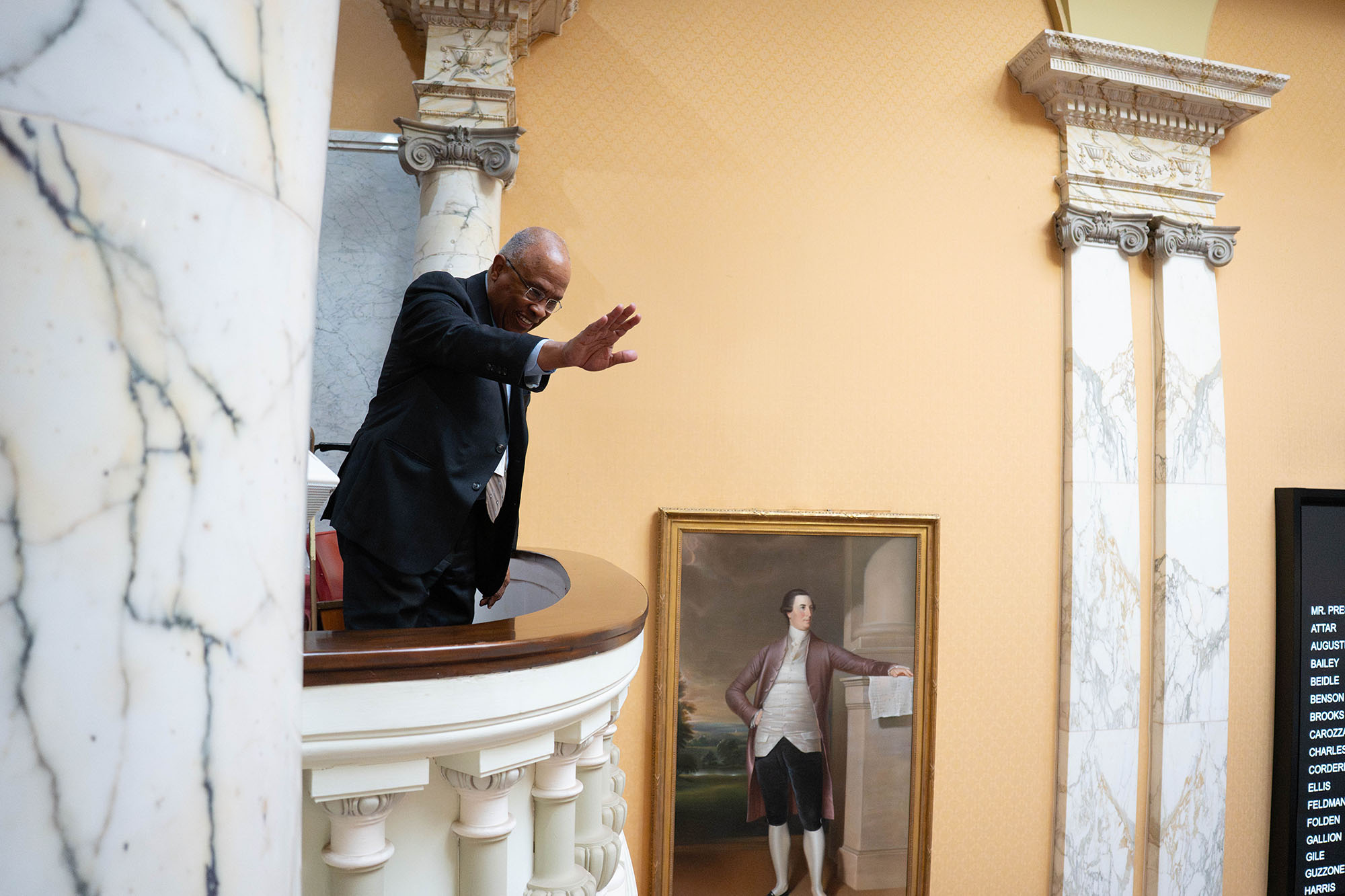 Kurt L. Schmoke waves while looking down from the balcony seating in the Maryland Senate chambers.