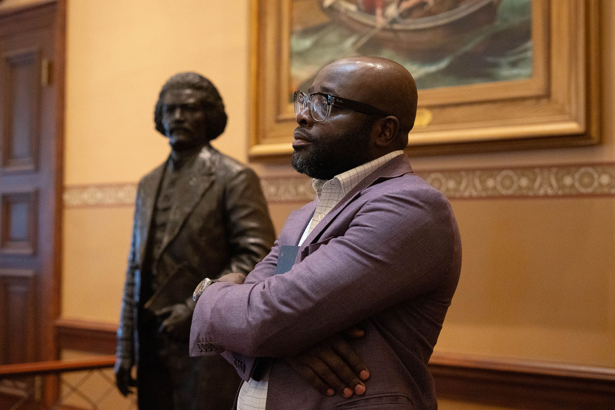 A student poses with a life-size statue of Frederick Douglass on display in the Maryland State House.