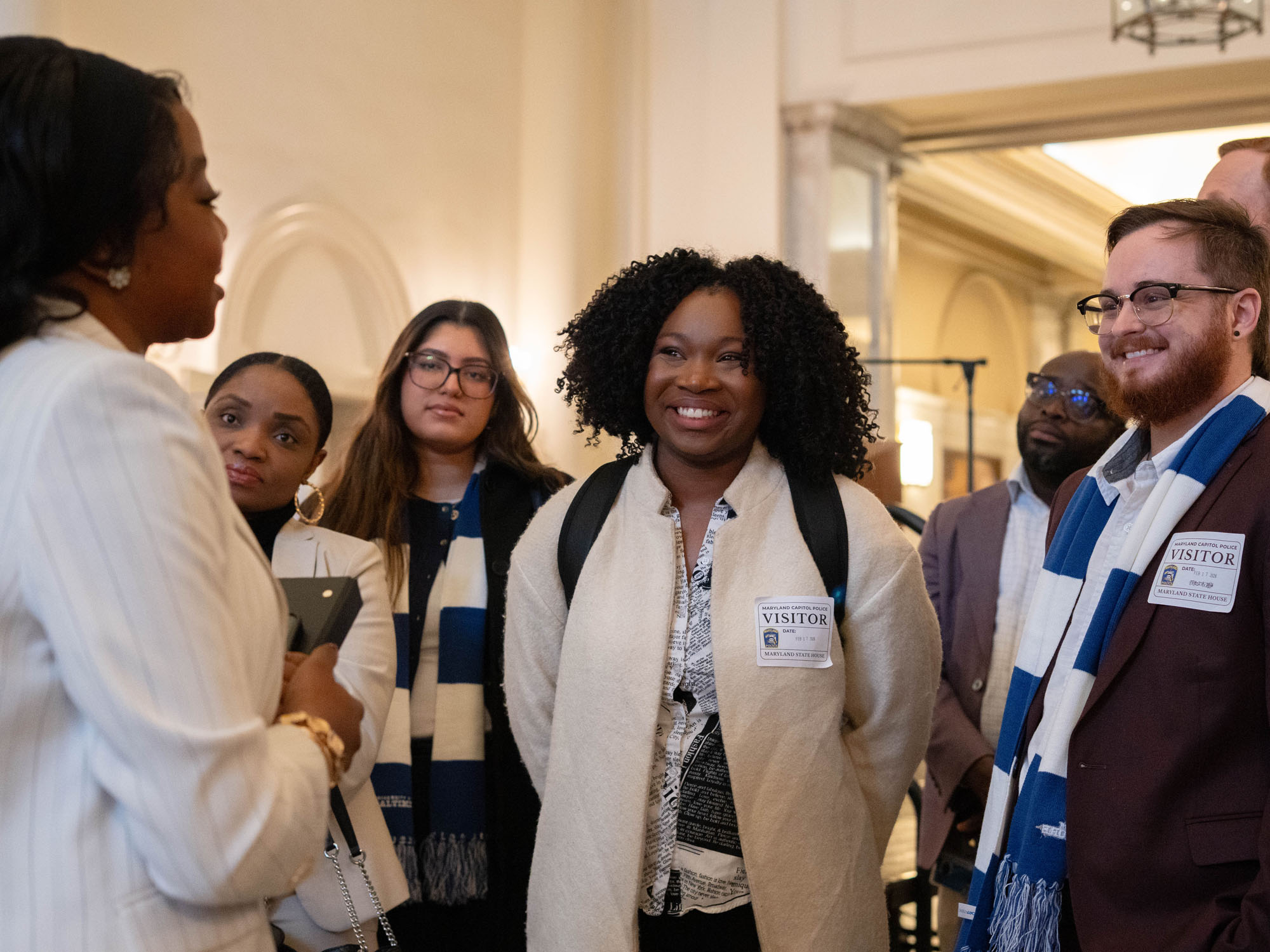 Students smile as they listen to a tour guide during a tour of the Maryland State House. 