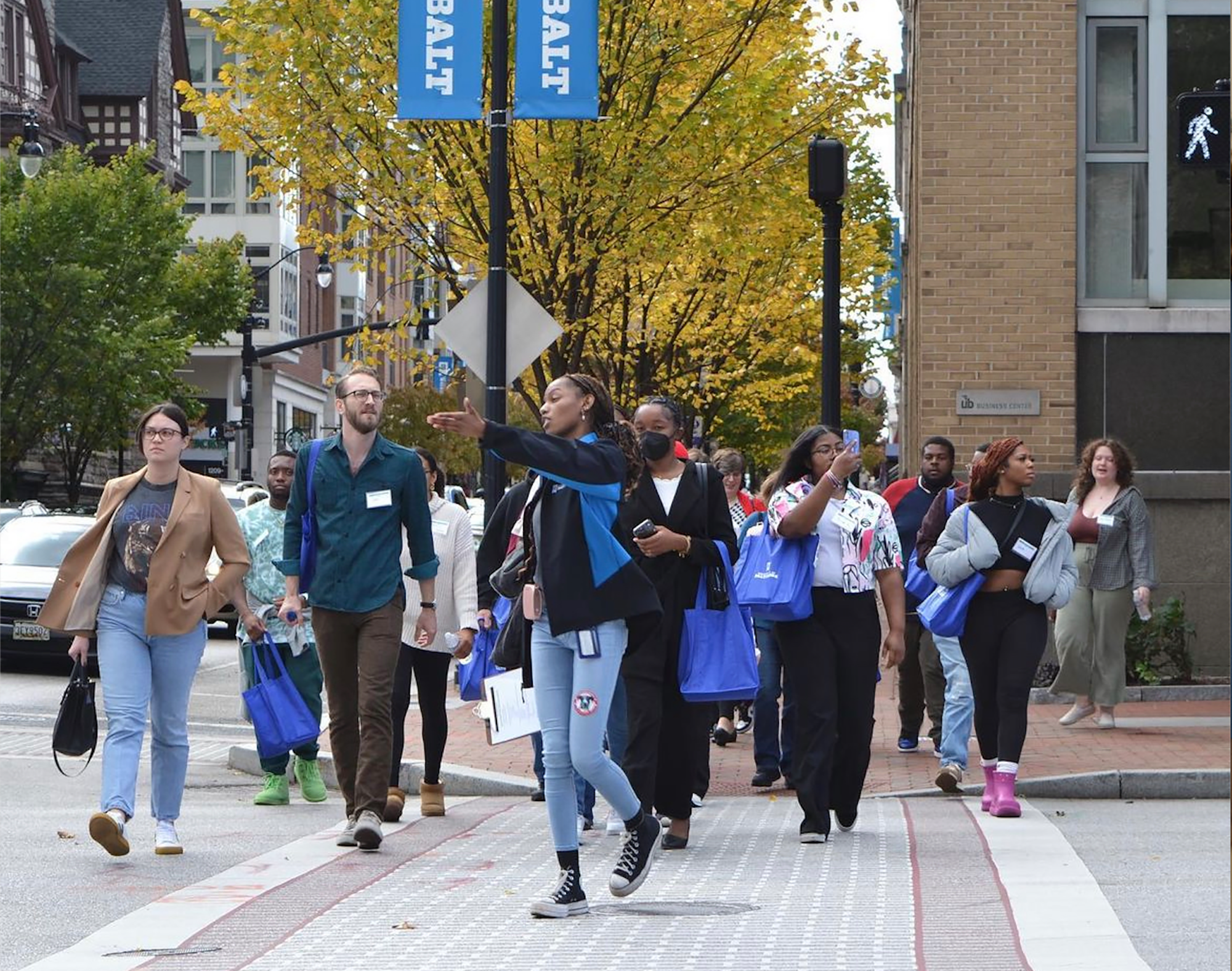 A student leads a campus tour for a large group on the University of Baltimore campus.