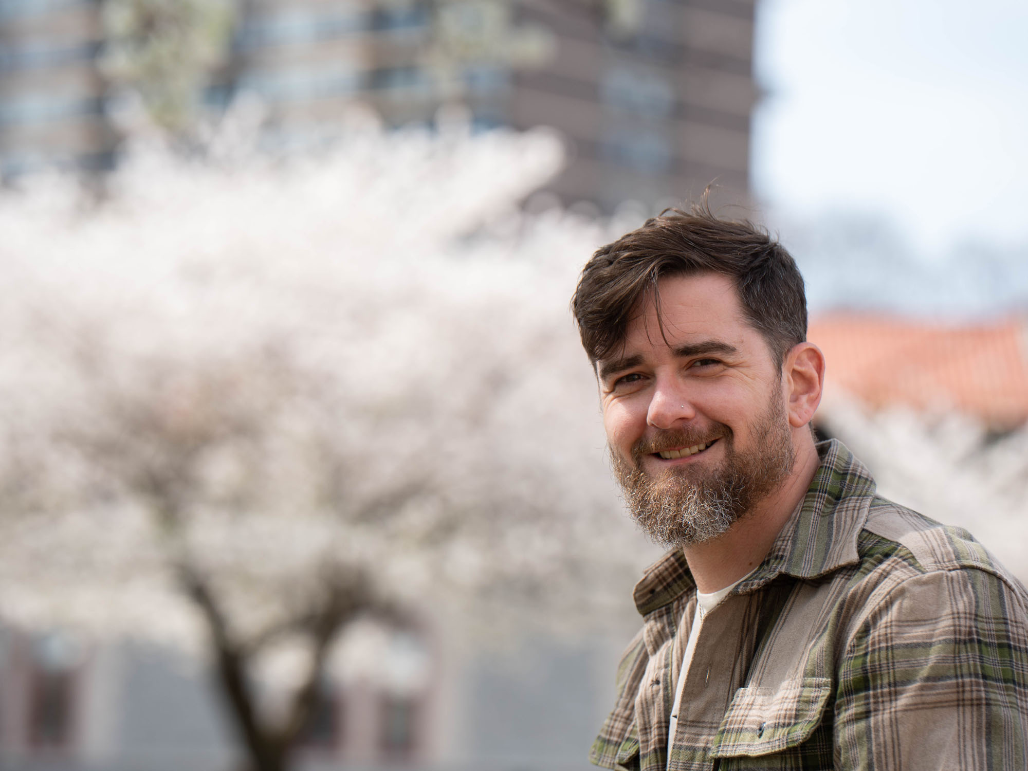 Bryant Lepic smiles while sitting in a monument park near The University of Baltimore's campus.