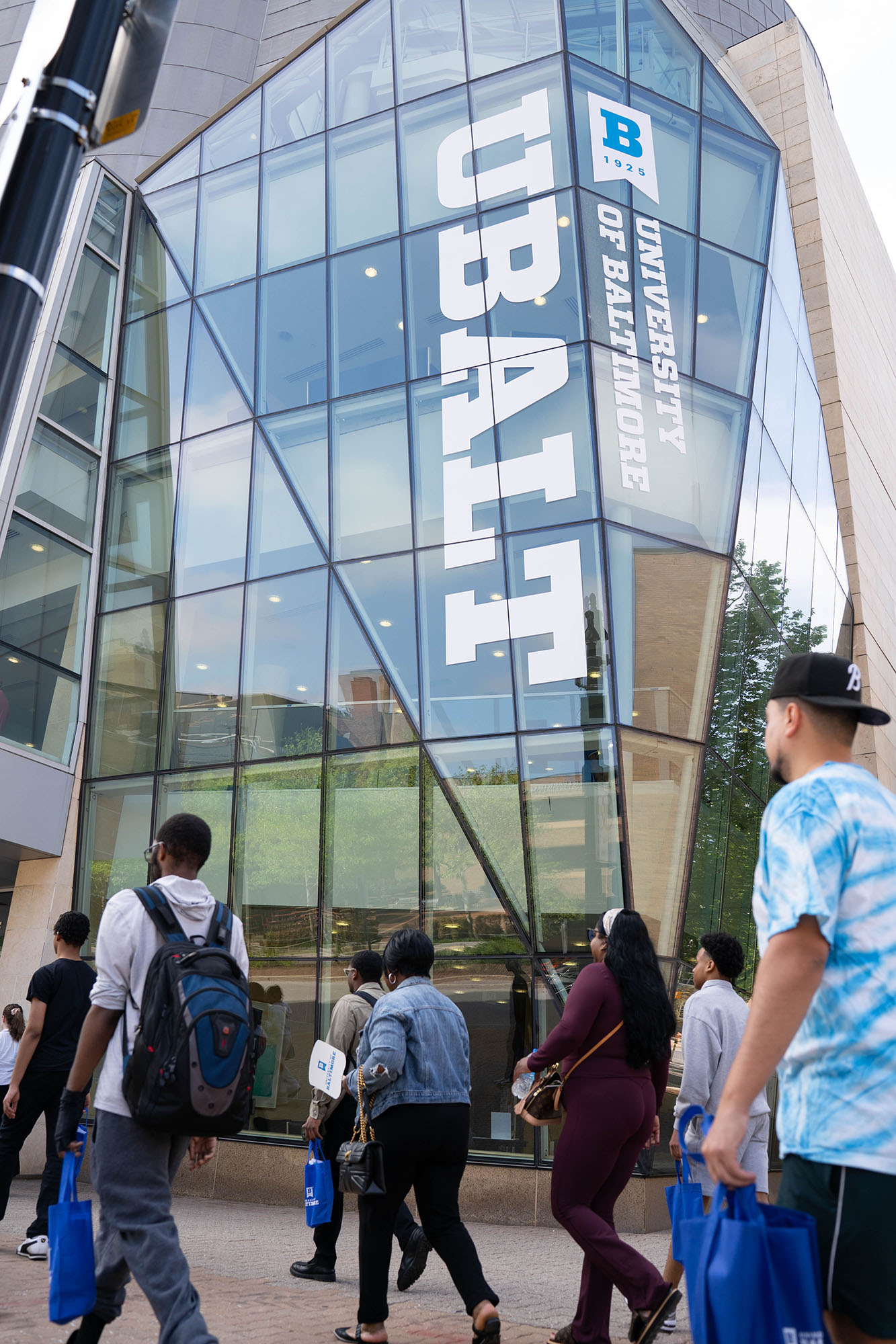 Students on a walking tour of The University of Baltimore walk by the UBalt Student Center. 