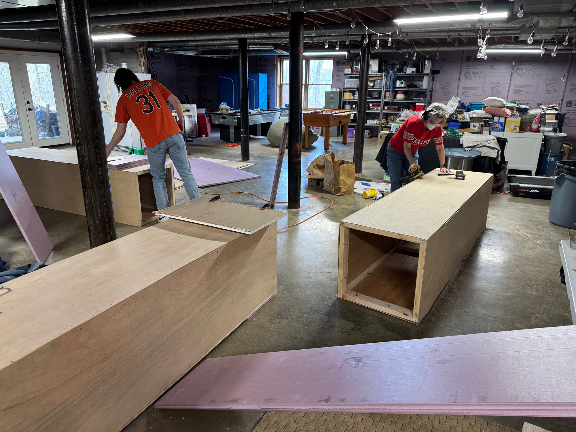 In a workspace, people craft large wooden boxes that become key pieces of a Centennial exhibit.