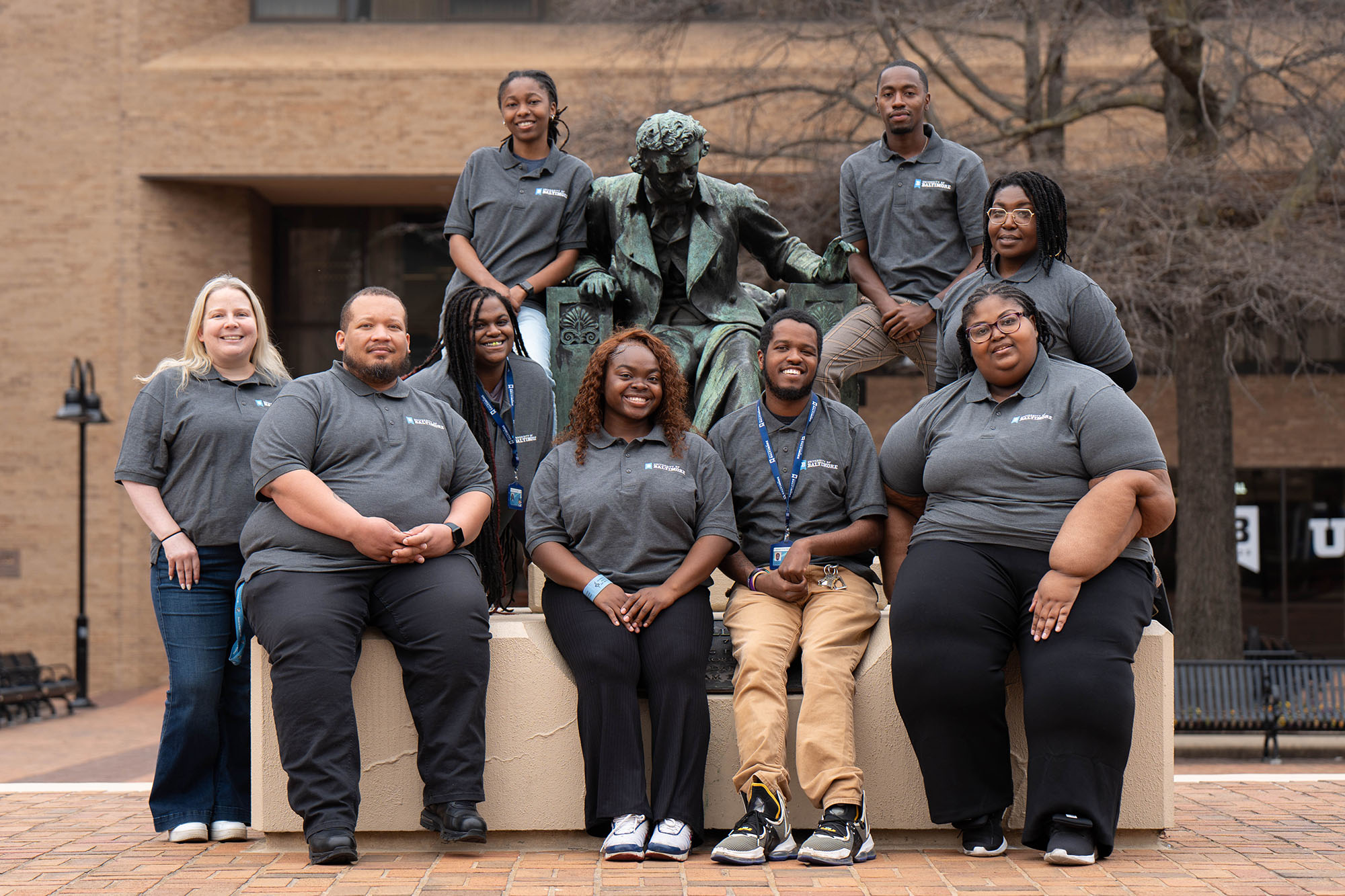 The 2025 orientation leaders pose with the Edgar Allan Poe statue at The University of Baltimore campus.