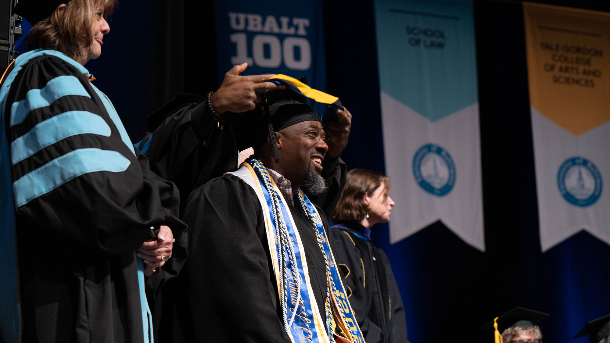 A graduate receives his hood during commencement. 