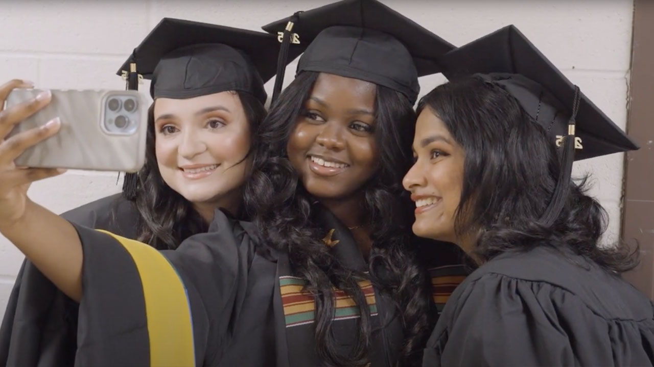 Three graduates take a selfie together