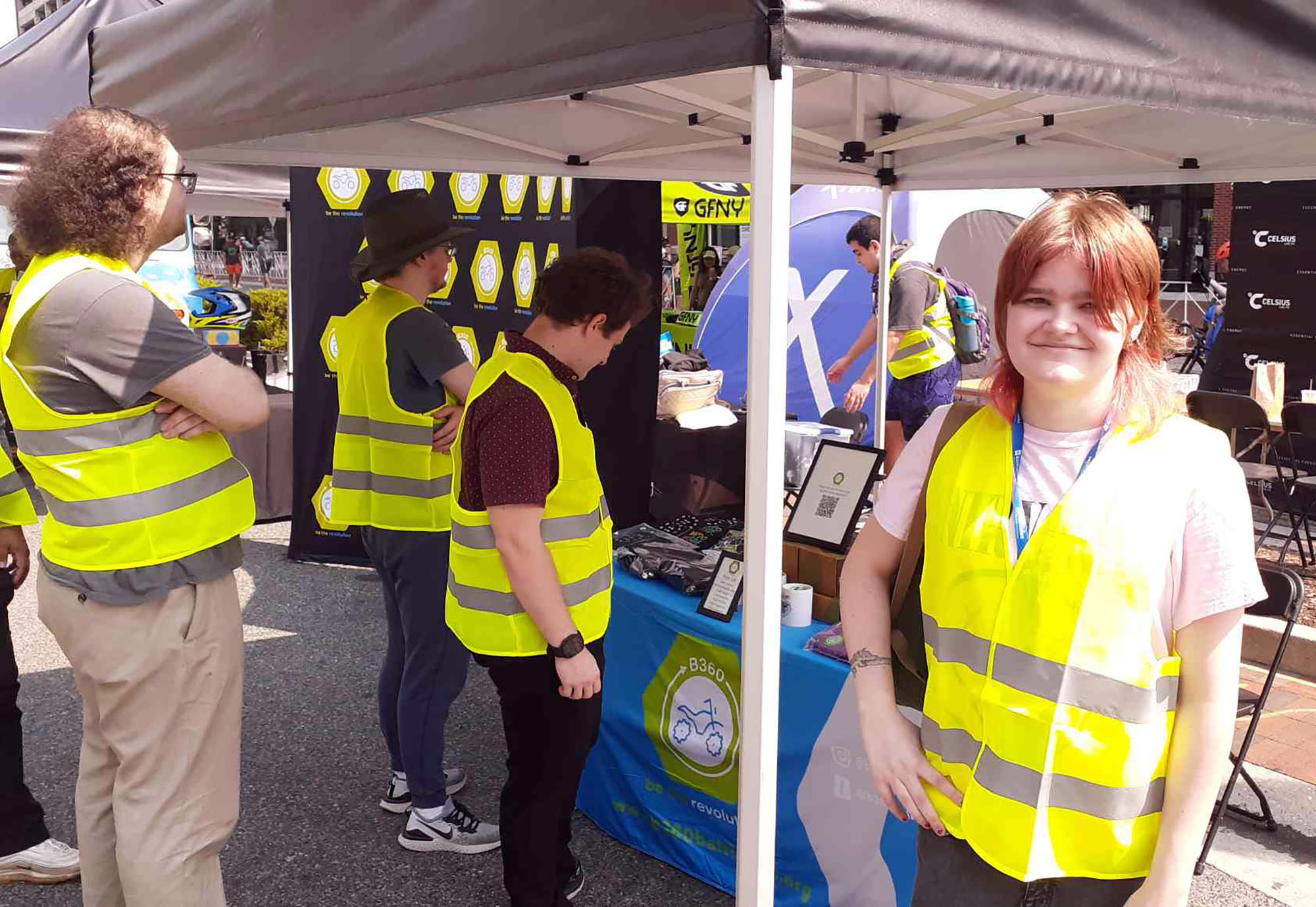 Students stand at a Baltimore event under a tent set up downtown.