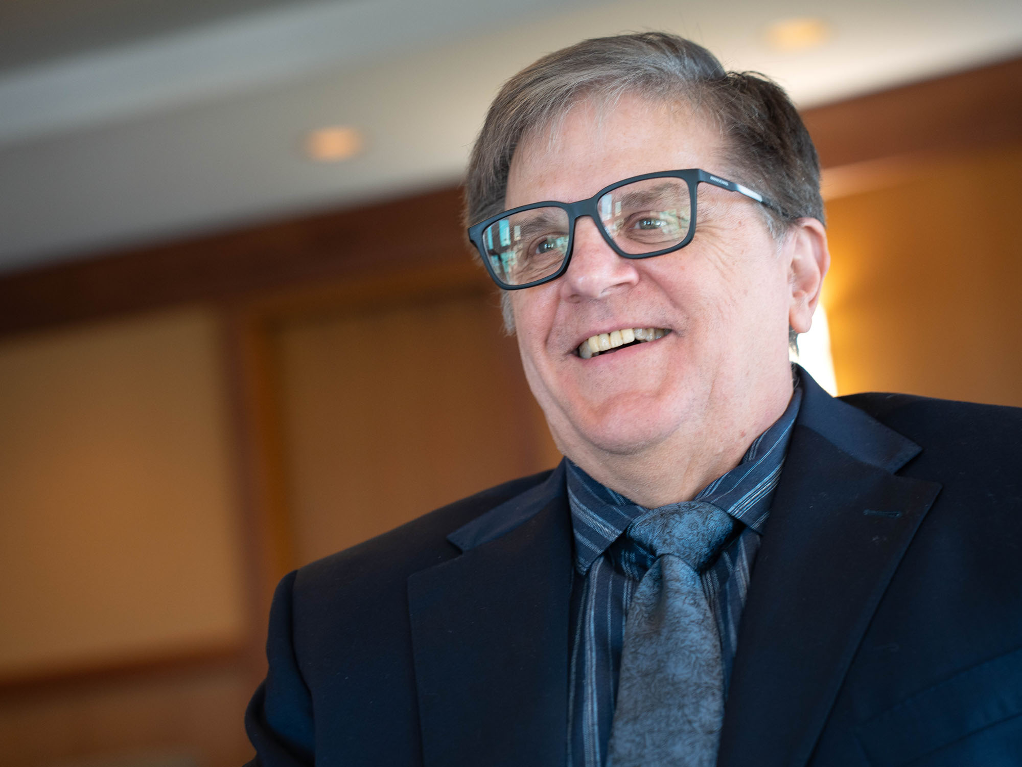 Dan Gerlowski smiles looking off camera while sitting in the dean's suite at The University of Baltimore.