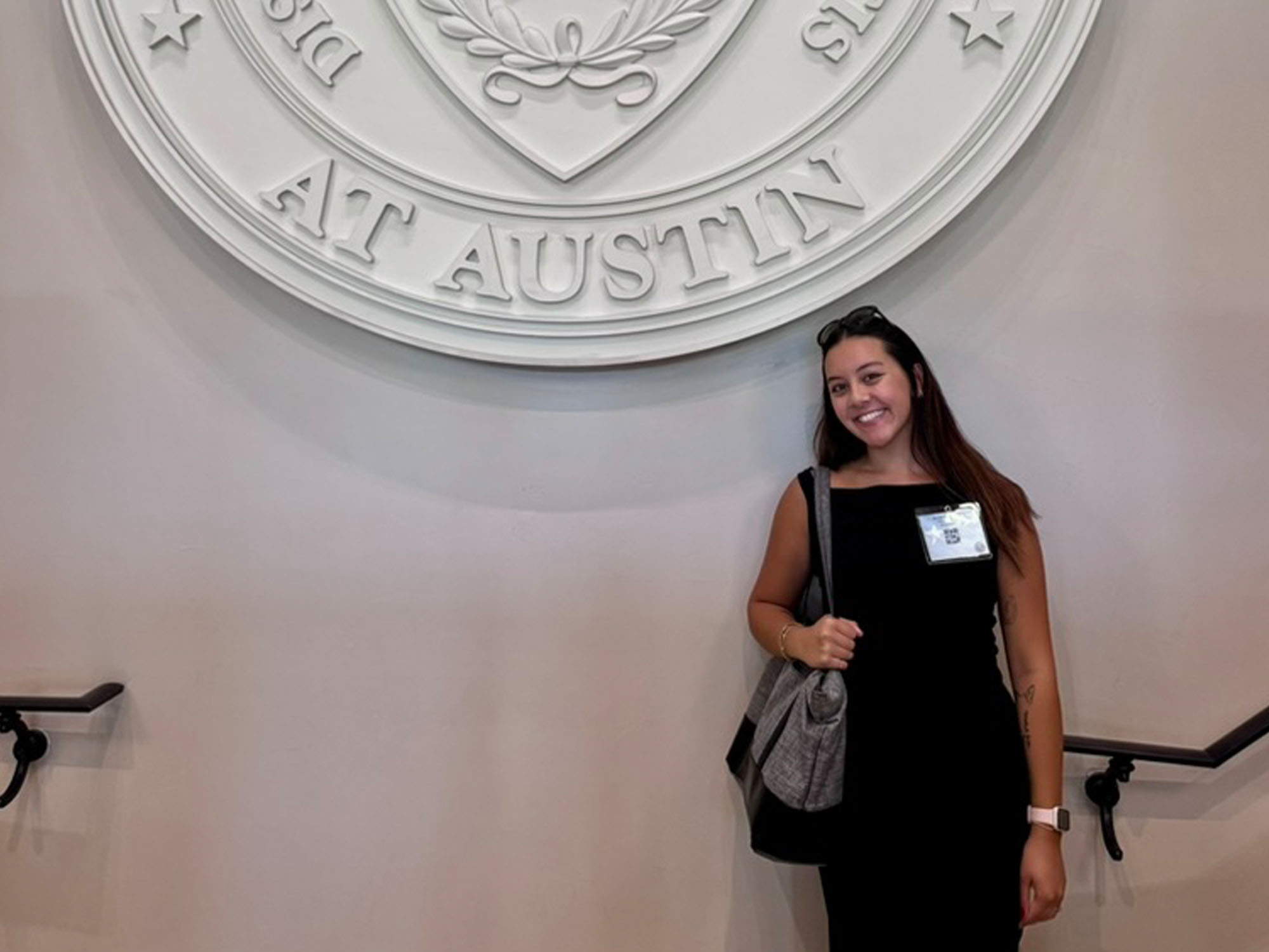 Danica, a UBalt student, stands in front of the University of Texas--Austin seal during a conference visit. 