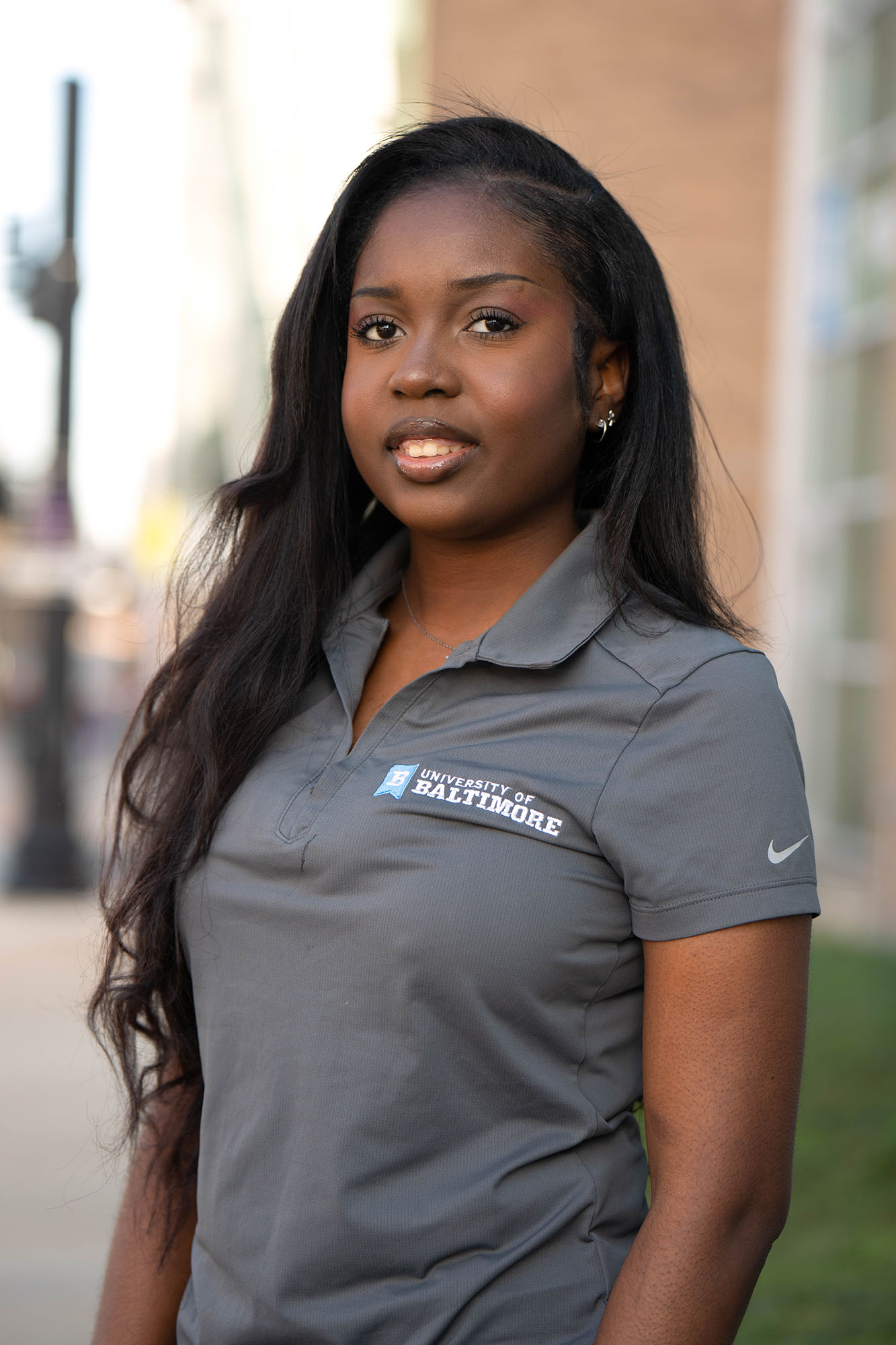 Deshanae Clarke poses for the camera while standing outside the Welcome Center at The University of Baltimore.