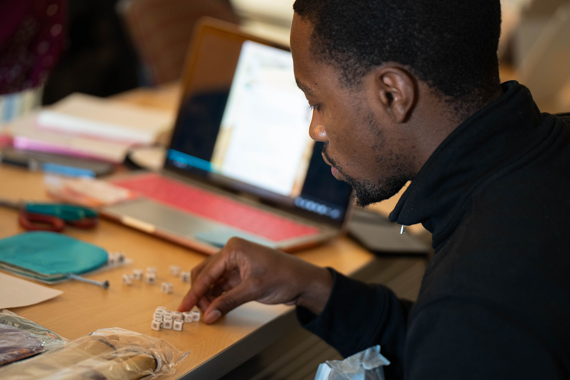 A student arranges letter-based pieces part of an escape room.