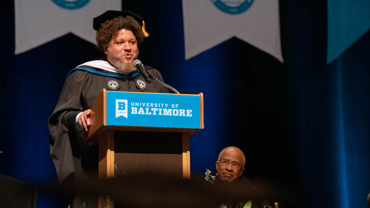 Fagan Harris speaks from the commencement stage podium.