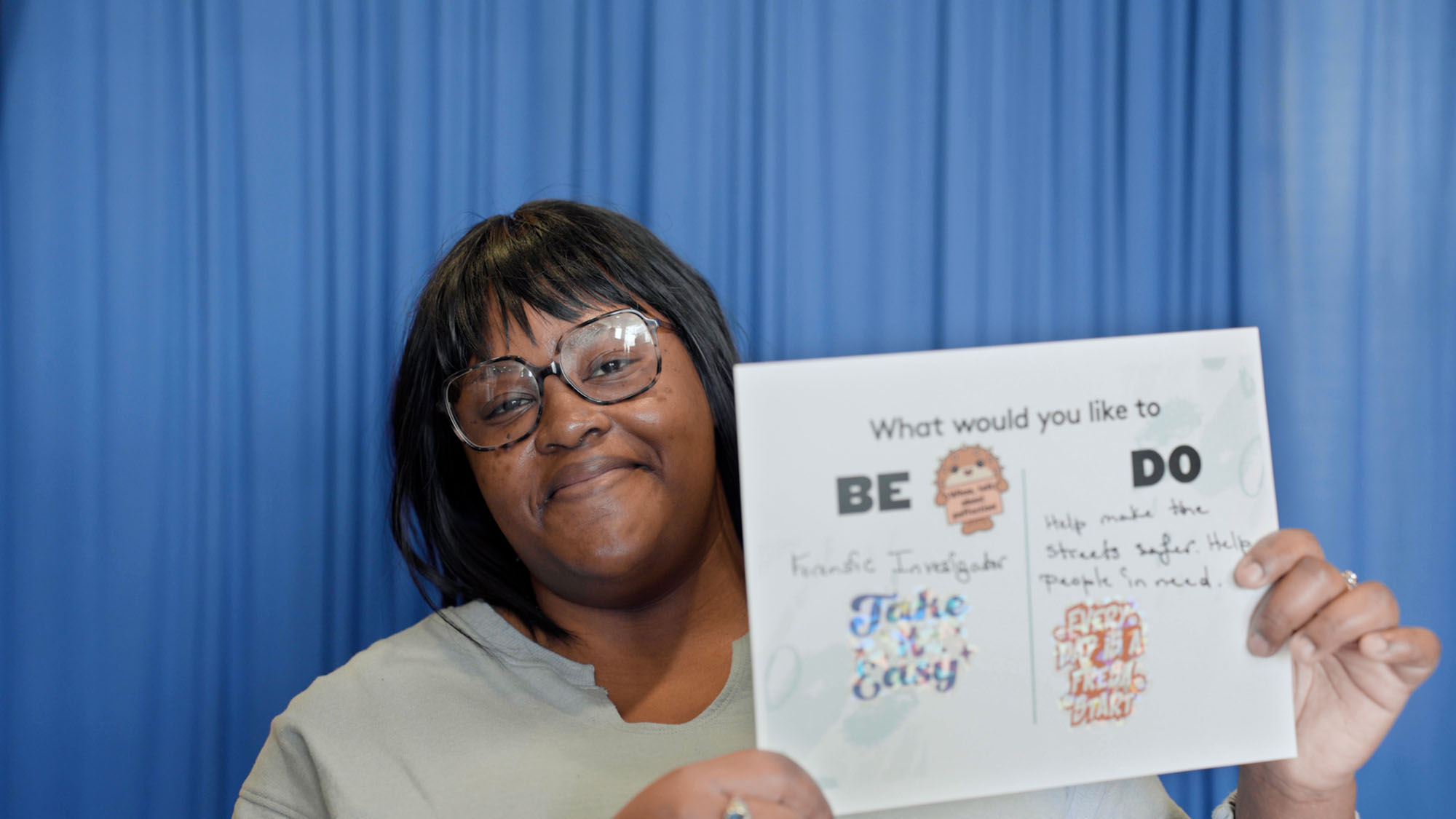 Garriana Phillips holds a piece of paper on which she brainstormed what what wants to do vs. what she wants to be in the future.