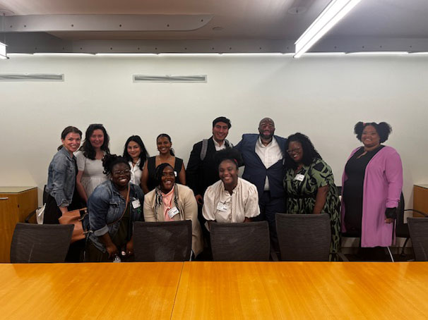 A large group of students pose in a conference room.