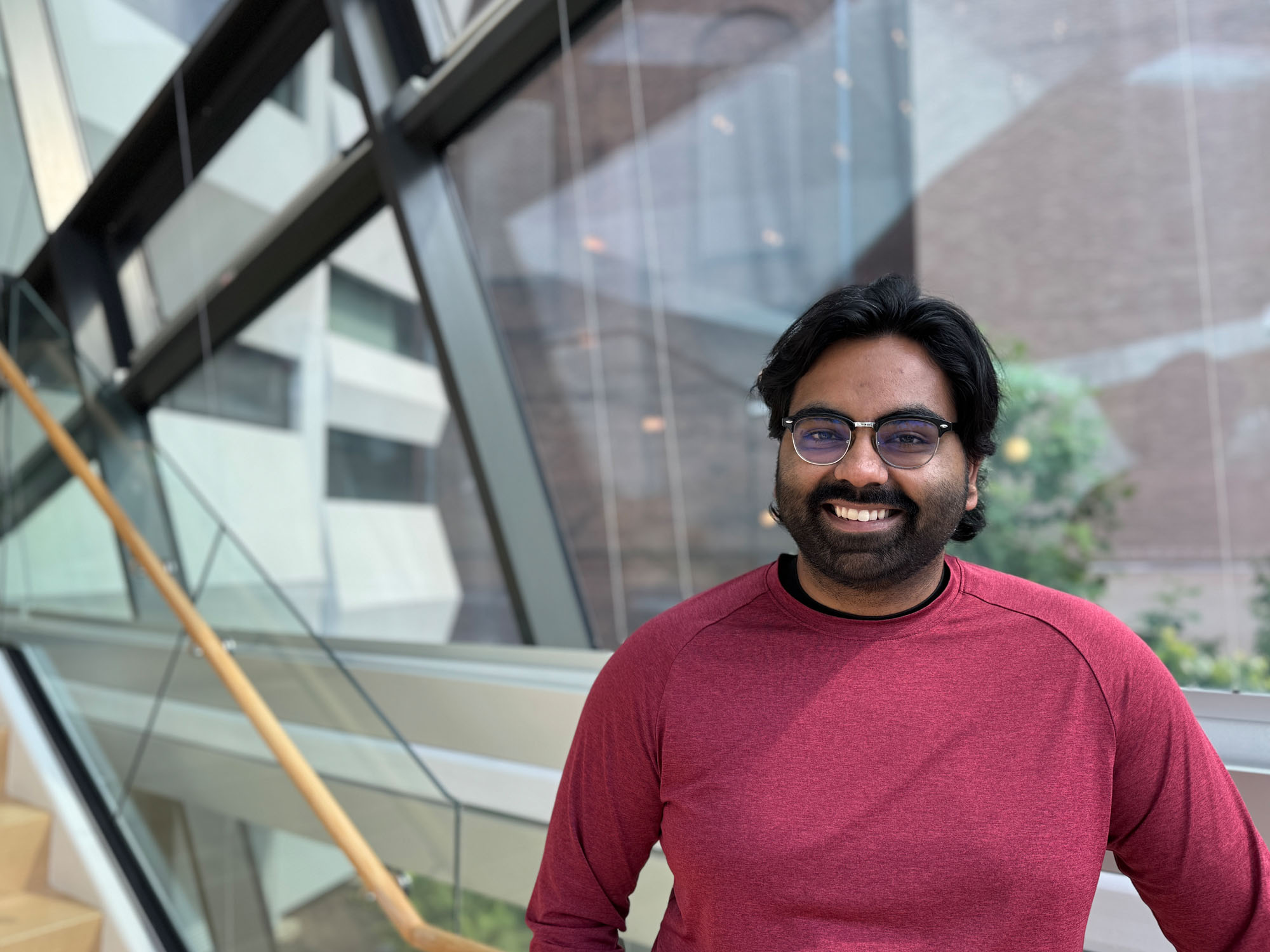 Hanu Pershad stands in the brightly lit stairwell at the campus library.