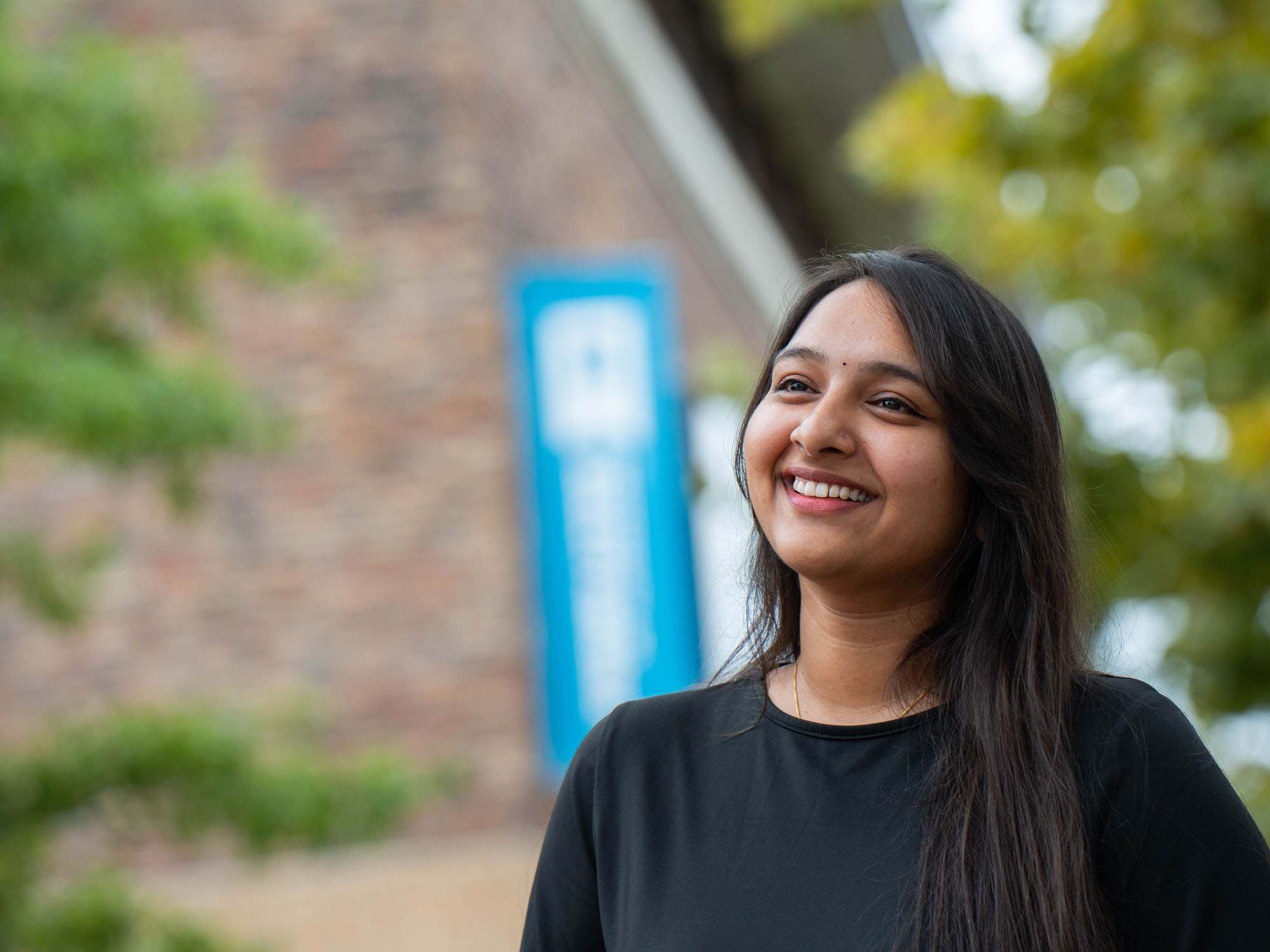 Harshitha Gajula smiles while looking on during a photo shoot on UBalt's campus
