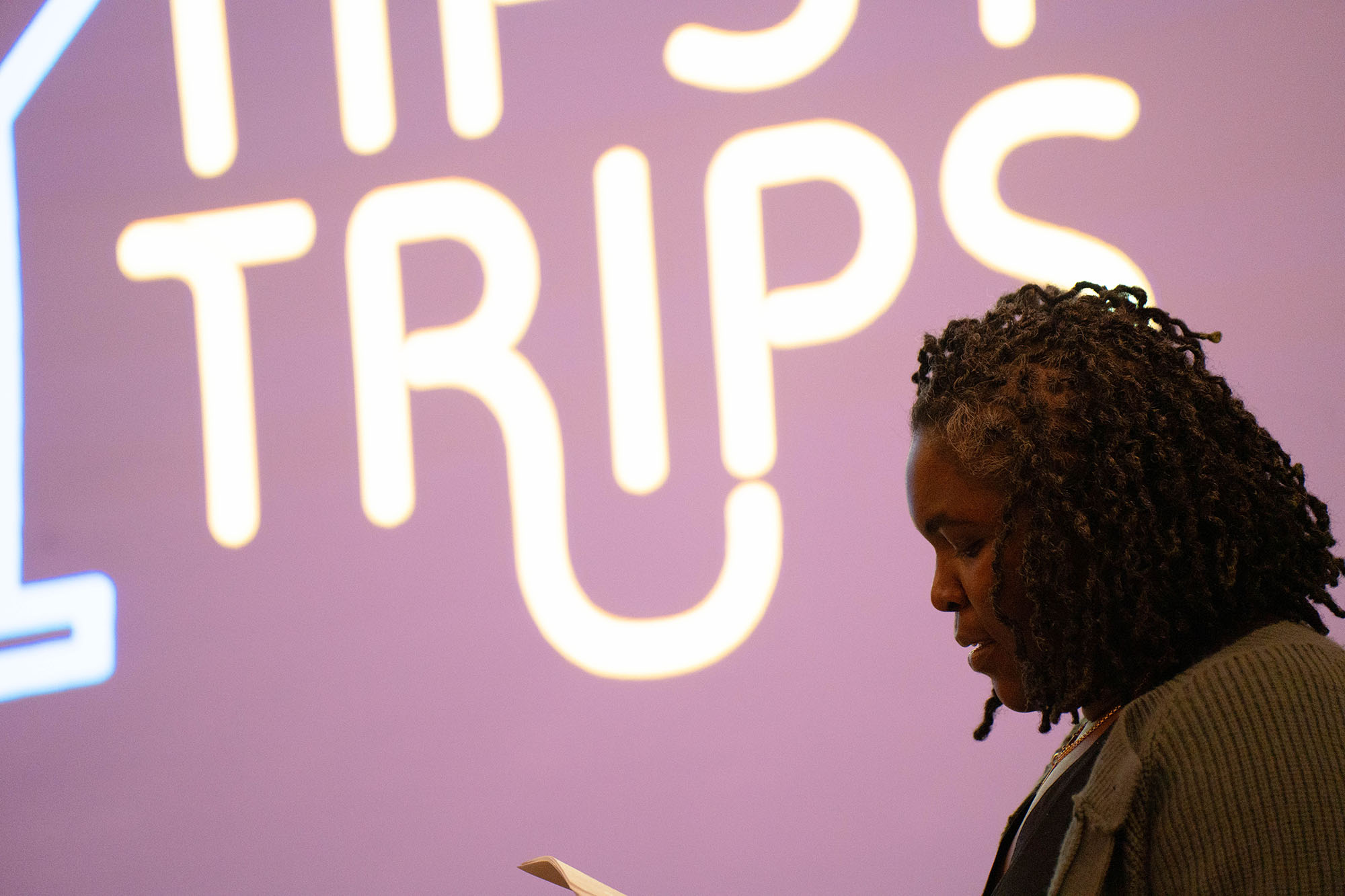 A silhouette of a student is seen in front of a purple screen that reads Tipsy Trips, the name of the client's company.