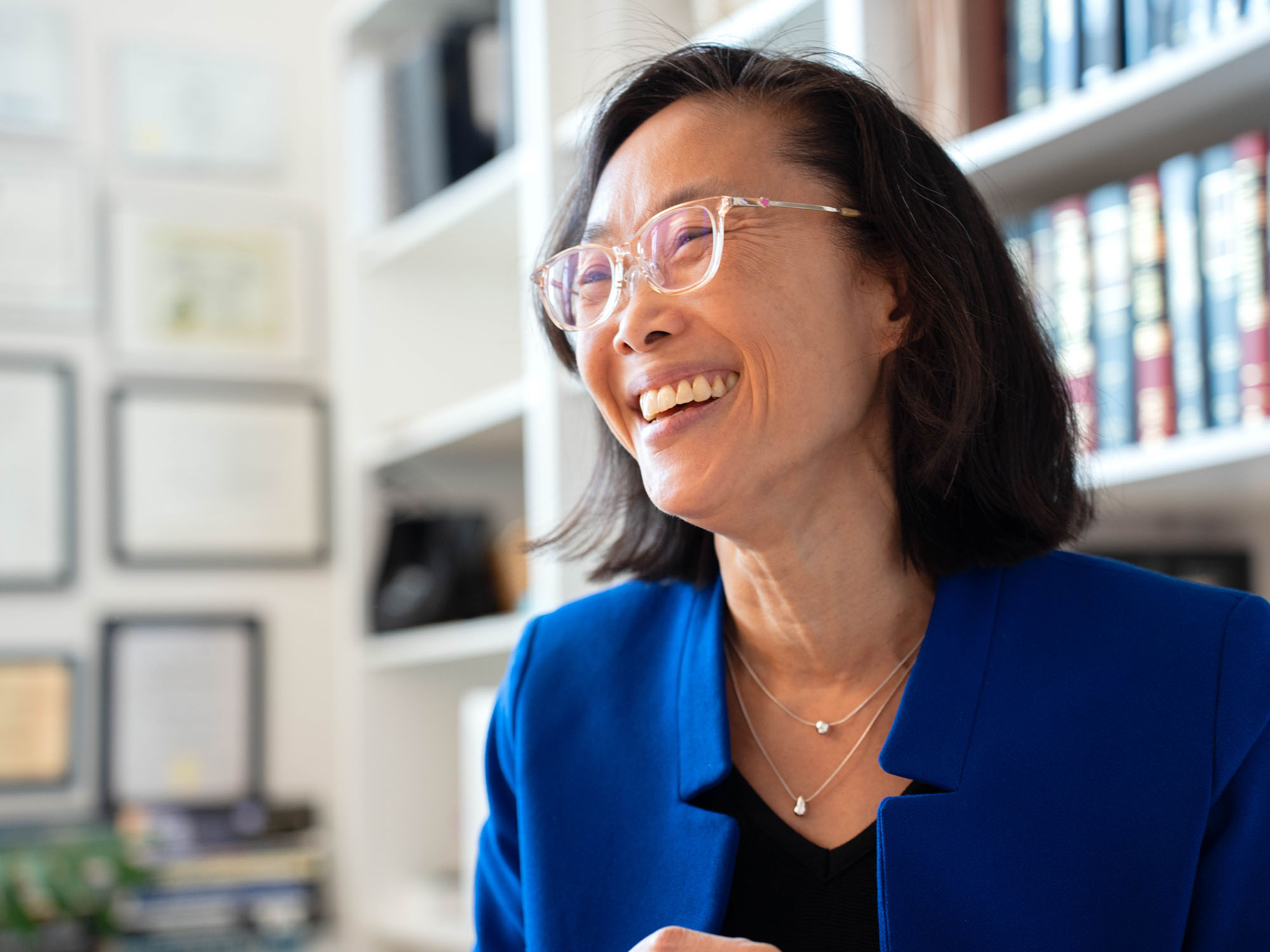 Jaime Lee, professor, smiles while looking on during a conversation in her office. 