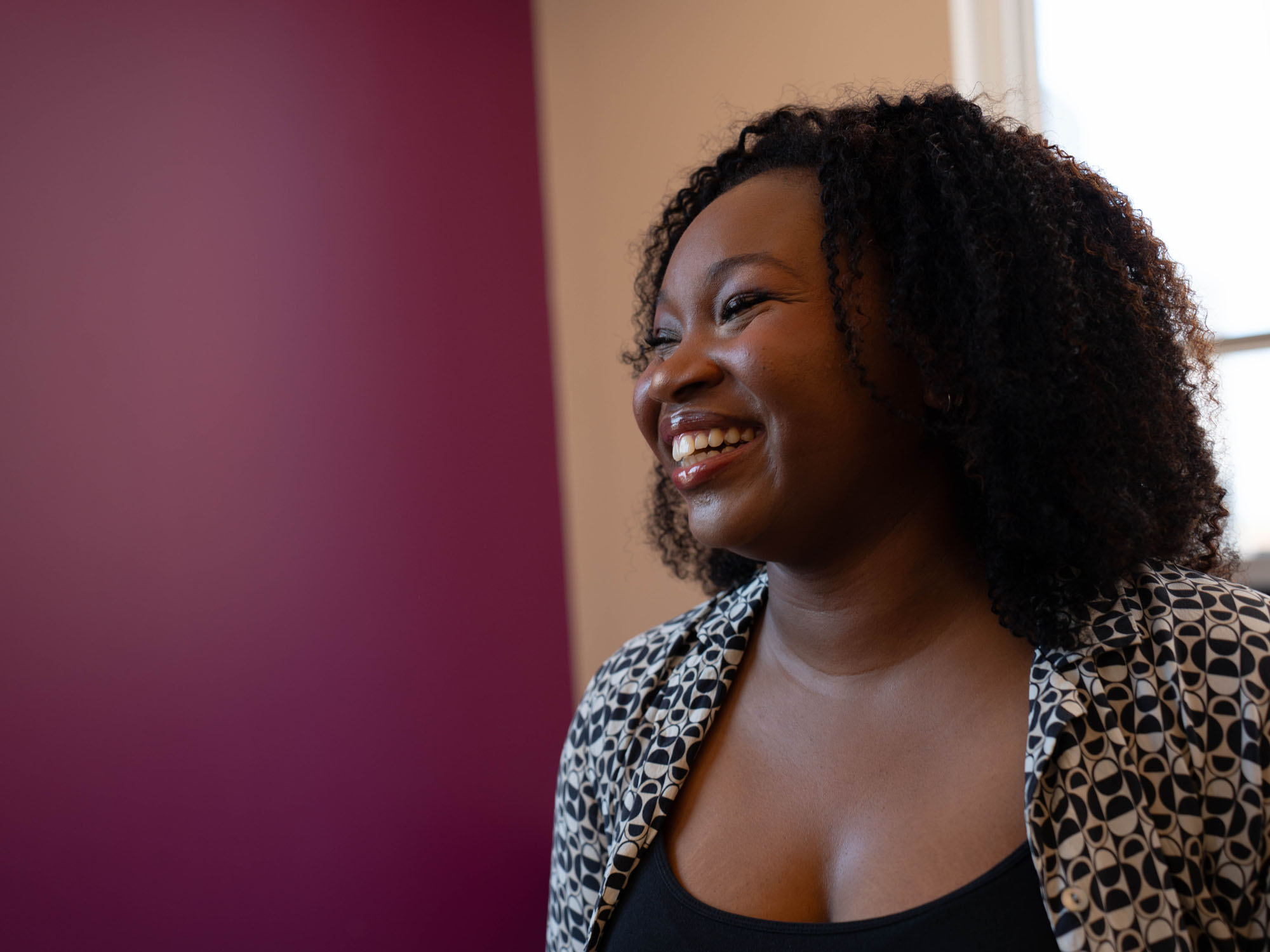 A student looks on while laughing.