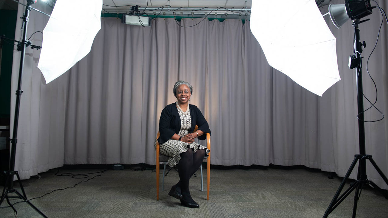 A woman poses under studio lights