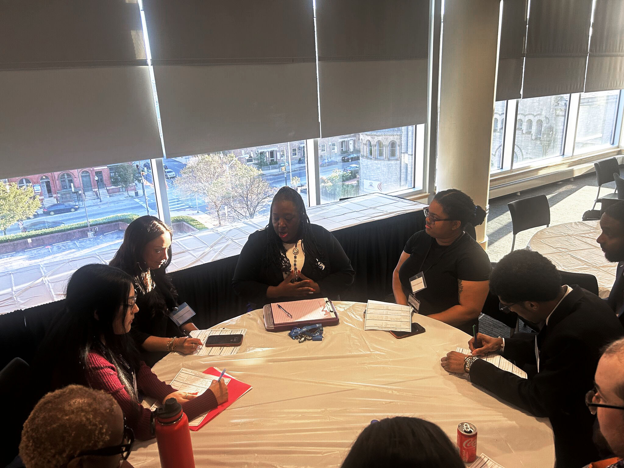 A career specialist at UBalt leads a table of students in conversation about tools they can use to improve their resumes and cover letters, including AI.