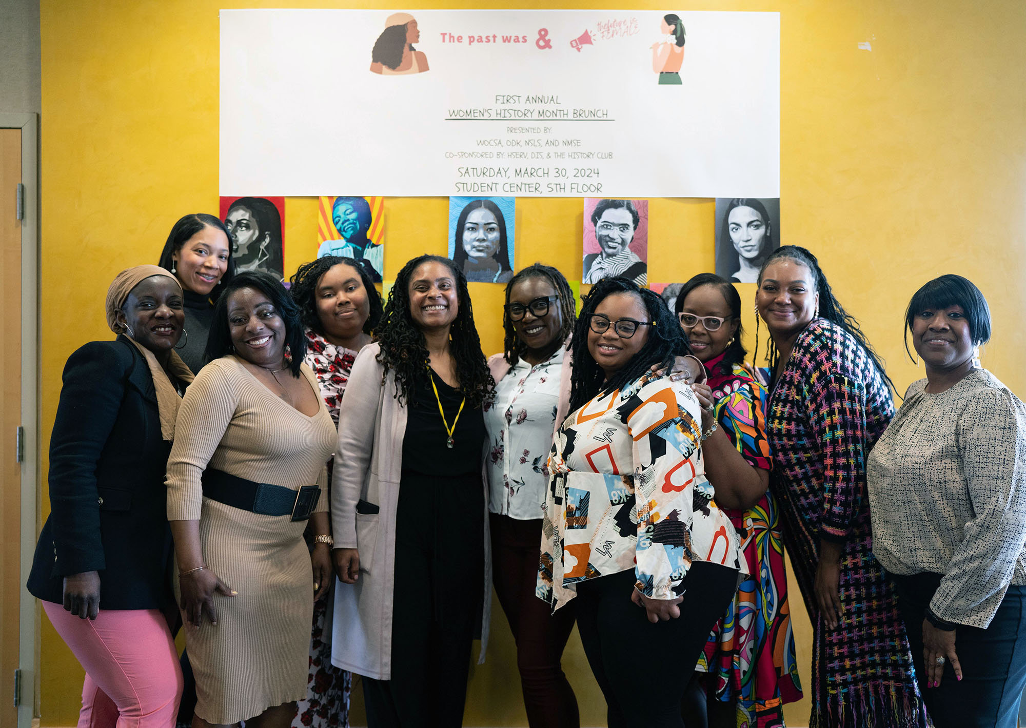 A group of students pose, smiling, during an event.
