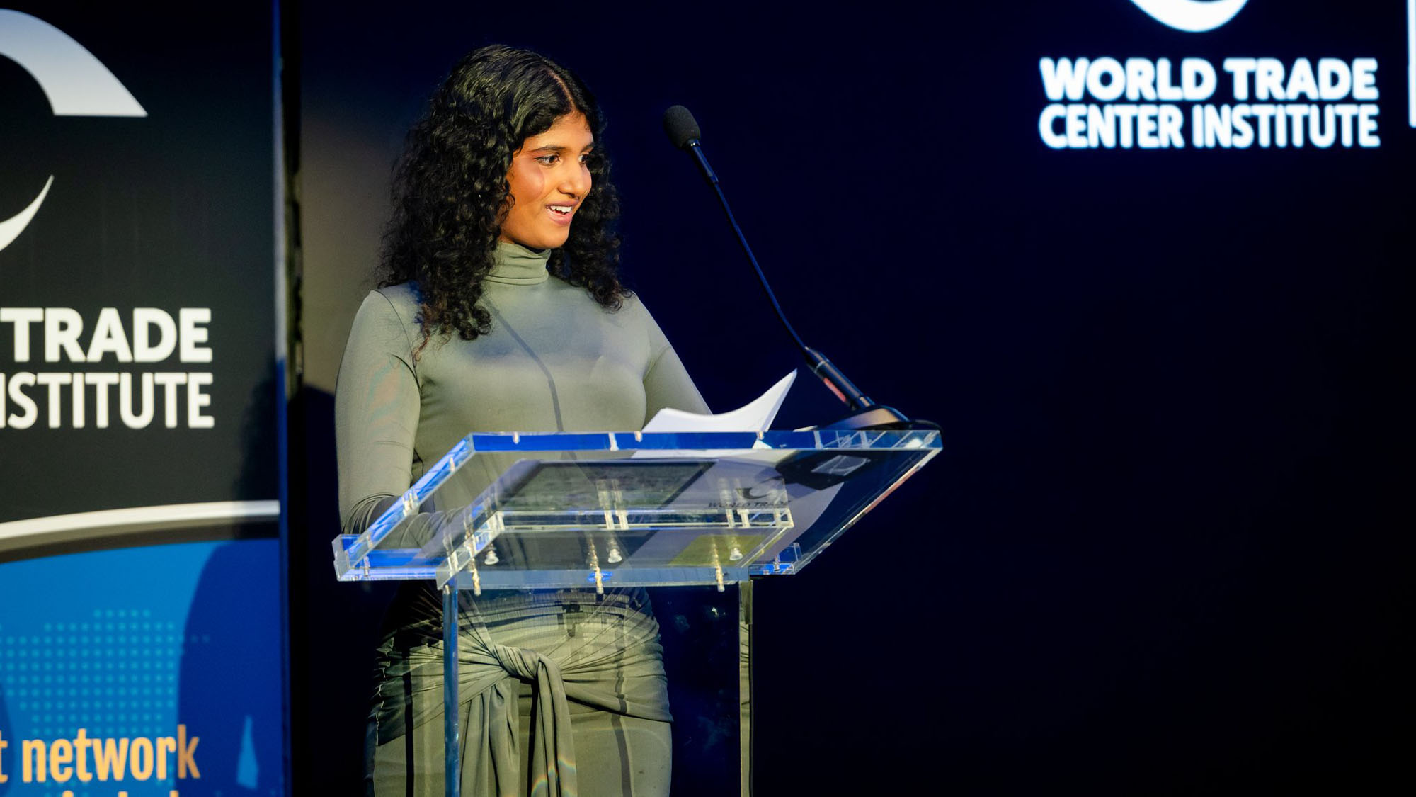 A student stands at a podium during an award ceremony.
