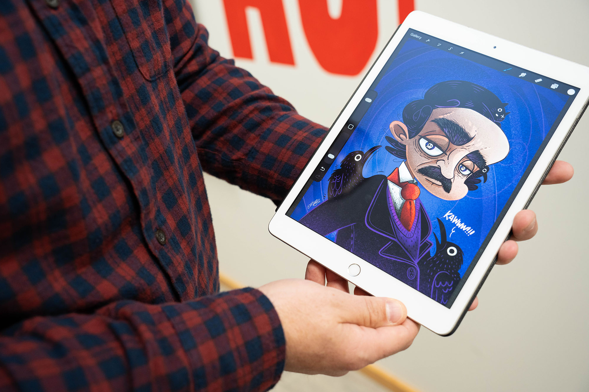 An illustration of Edgar Allan Poe, with exaggerated features, is shown on an iPad.