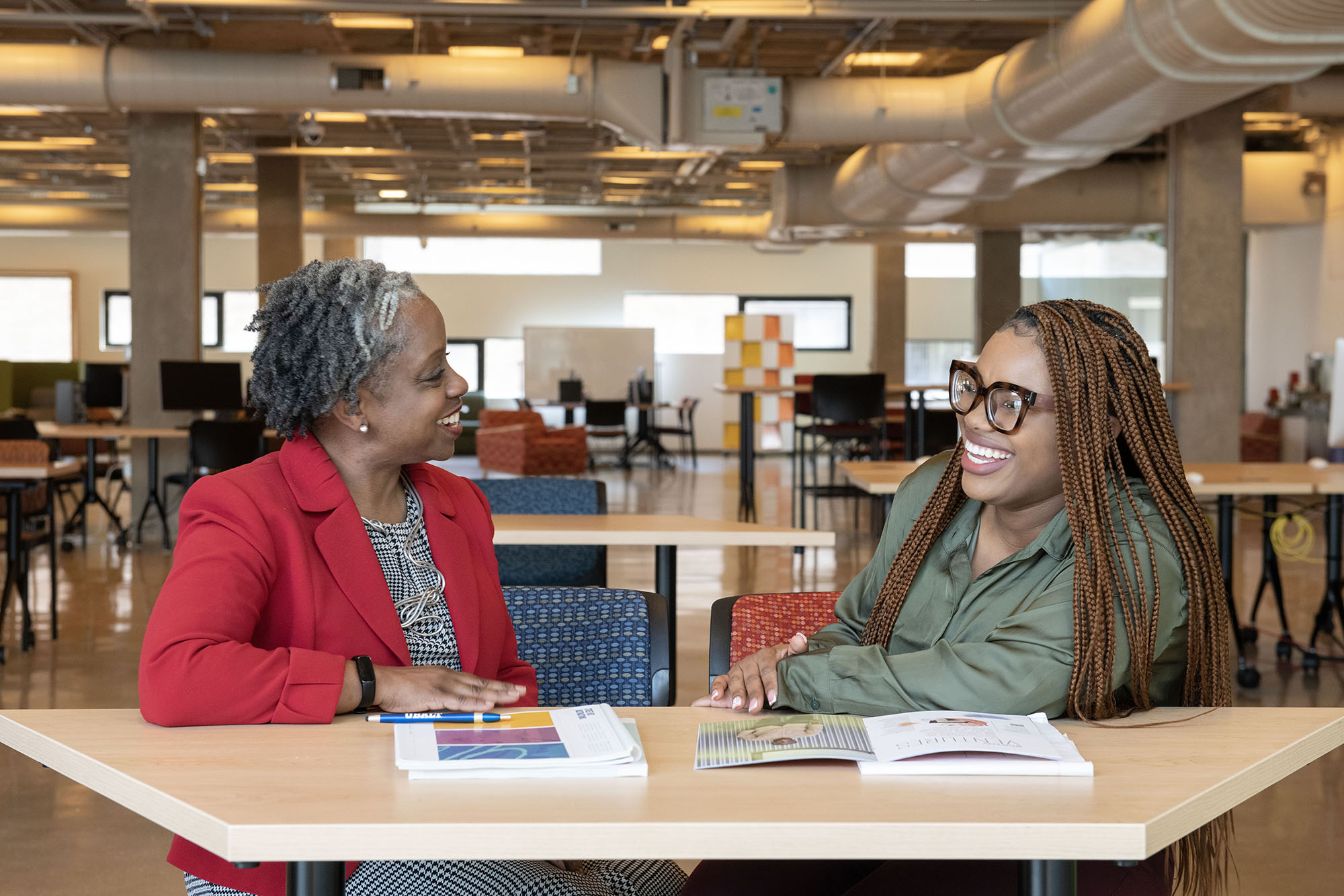 Staff and student share a laugh during a one-on-one meeting in the library.