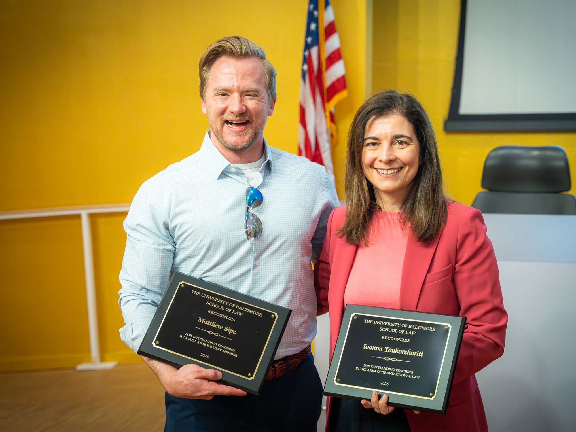 Two faculty members pose with award plaques at a University of Baltimore School of Law recognition ceremony.