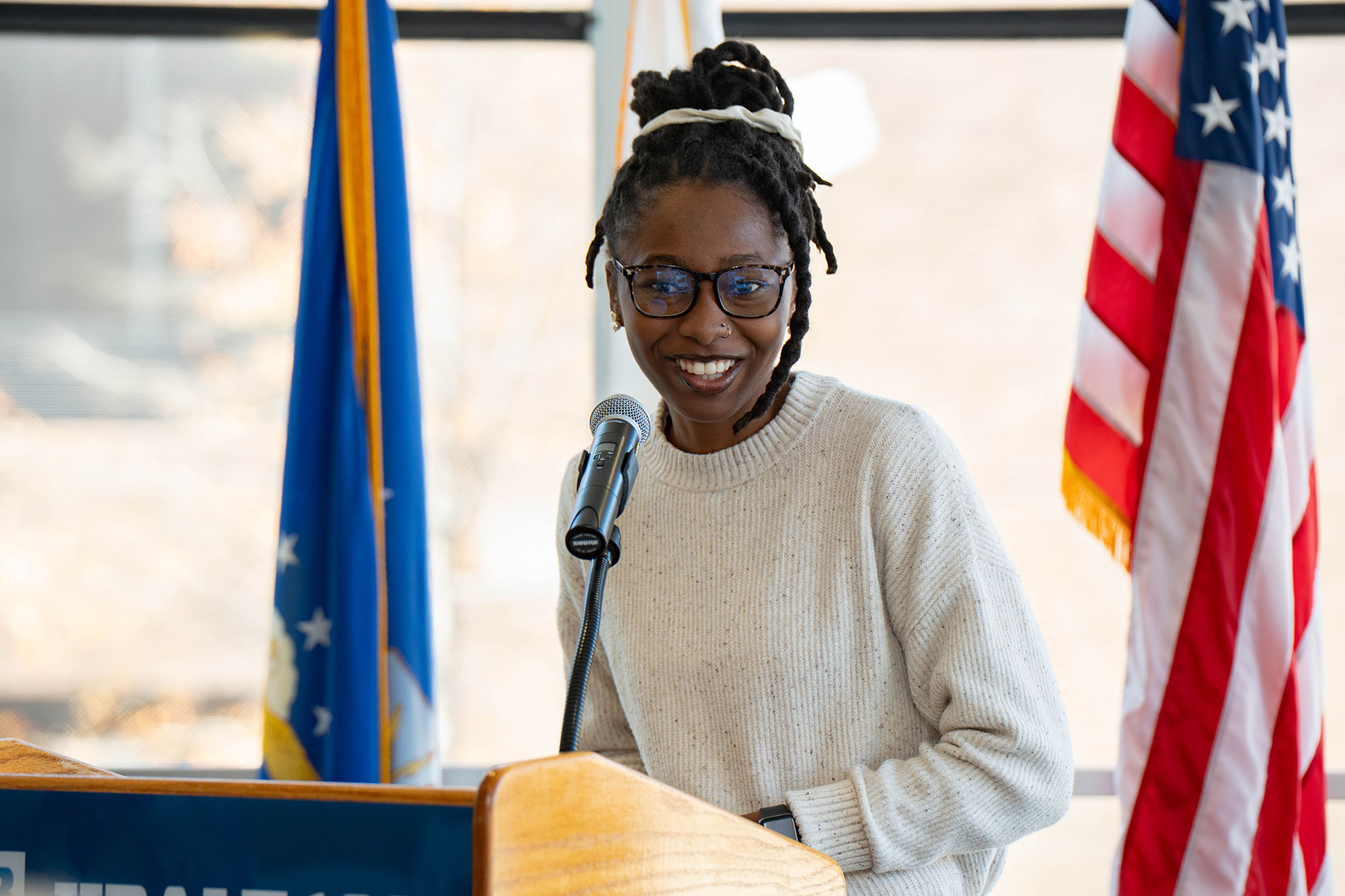 A student smiles at the camera from the podium
