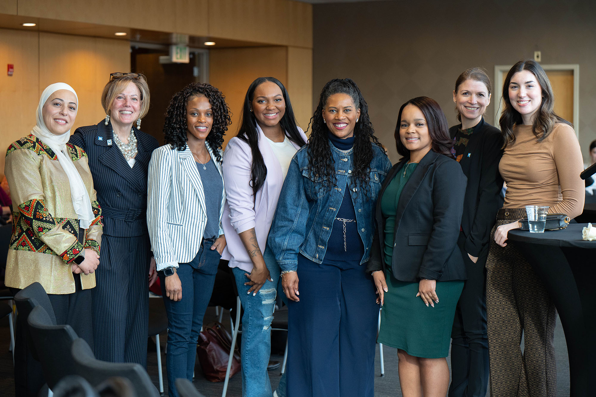 The eight panelists from the International Women's Day event pose for a group photo.