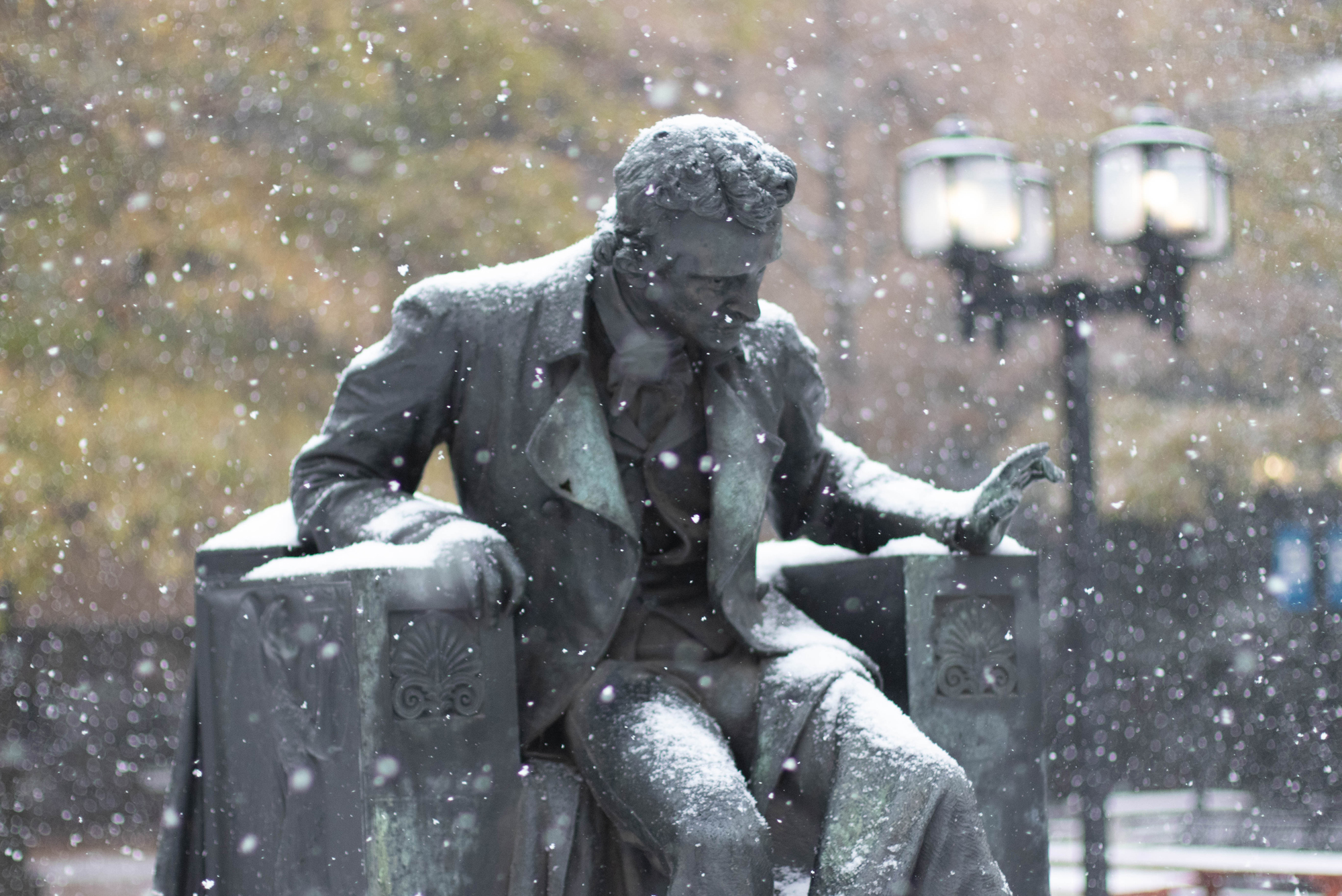 a statue of Edgar Allan Poe during a snowstorm on the University of Baltimore campus
