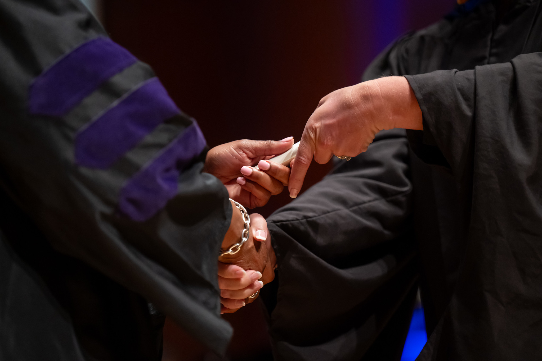 A graduate receives a diploma during the University of Baltimore School of Law commencement ceremony.