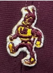A Bee mascot for the University of Baltimore, probably from the 1970s. The bee is anthropomorphic, and looks to be marching forcefully to the left. The Bee is maroon with yellow stripes and has the letters UB on its chest.