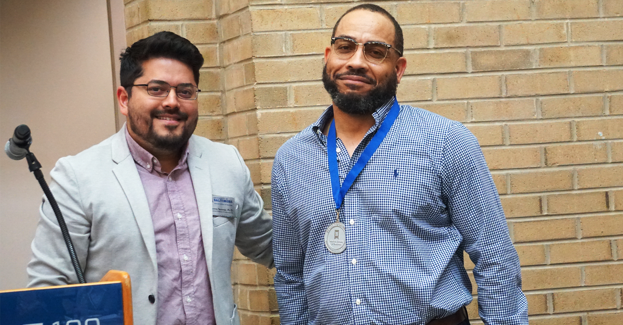 Dr. Sanwar Sunny present the Ratcliffe Entrepreneurship Fellows Medallion to James Bugg.