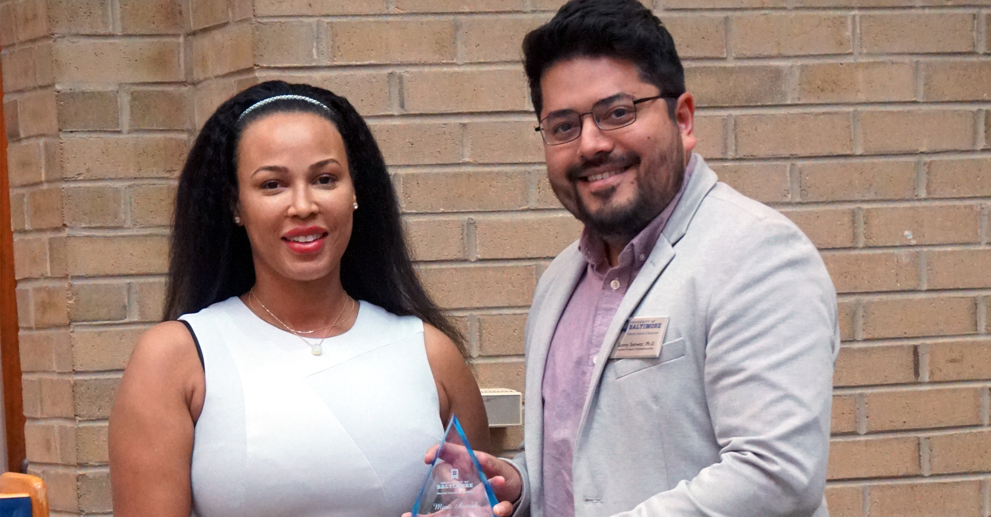Dr. Sanwar Sunny presents the Entreprenuership Merit Award to Aasha Mikha’El.