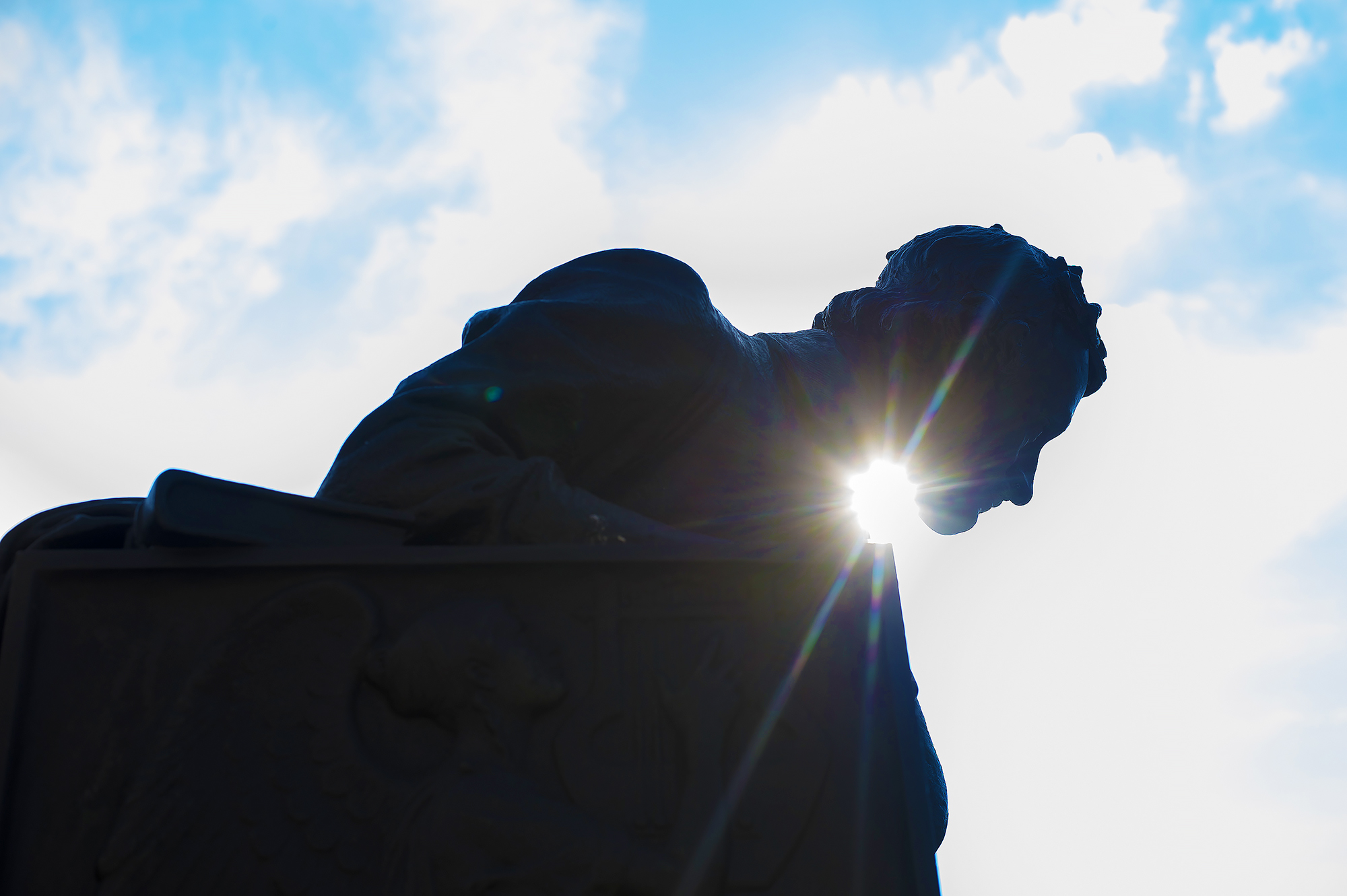 strong sunlight in the summer shining on the Edgar Allen Poe Statue on the UBalt campus