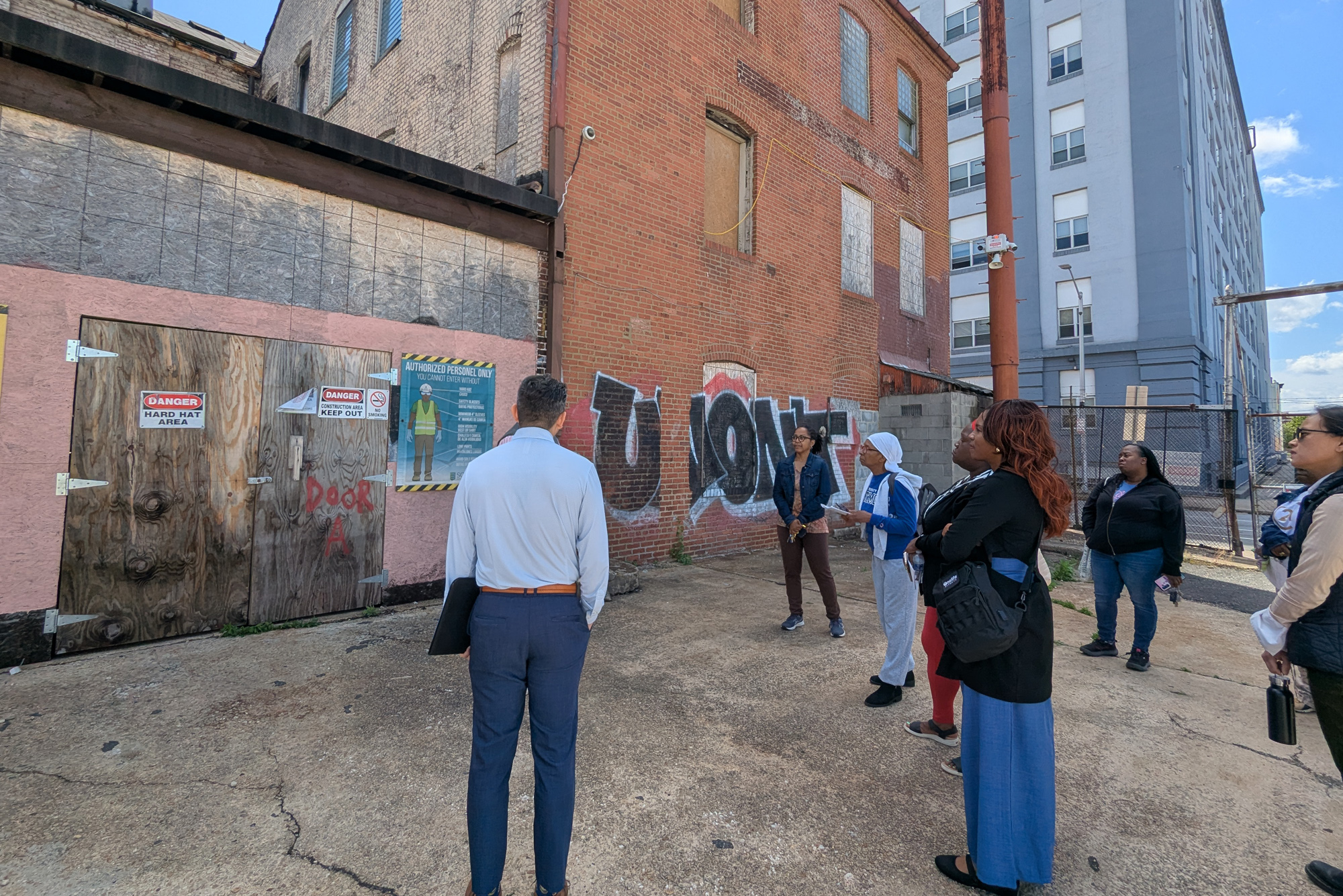 Students stand near grafitti covered buildings