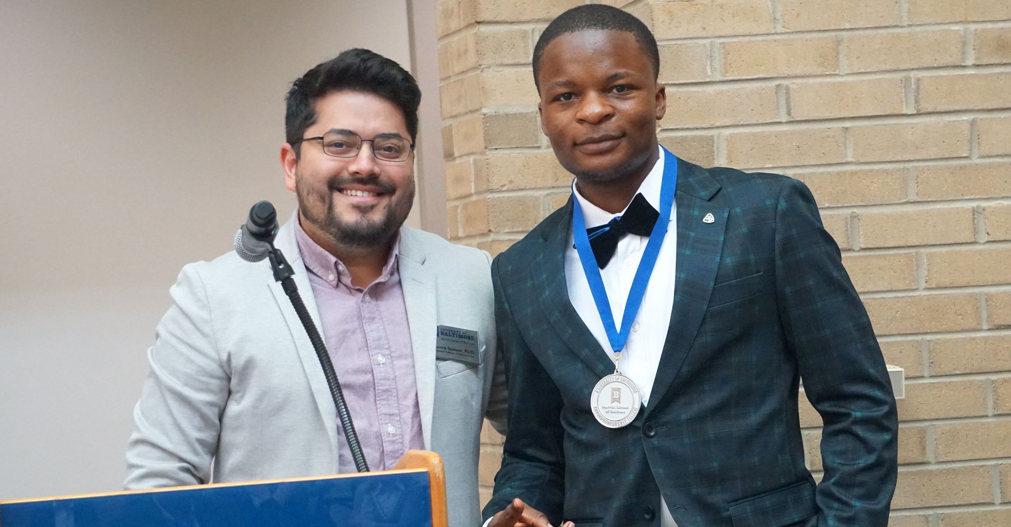 Dr. Sanwar Sunny present the Ratcliffe Entrepreneurship Fellows Medallion to Michael Kemakolam.