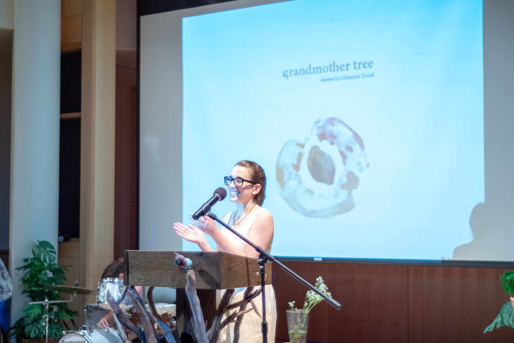 a student speaks at a presentation in front of a screen