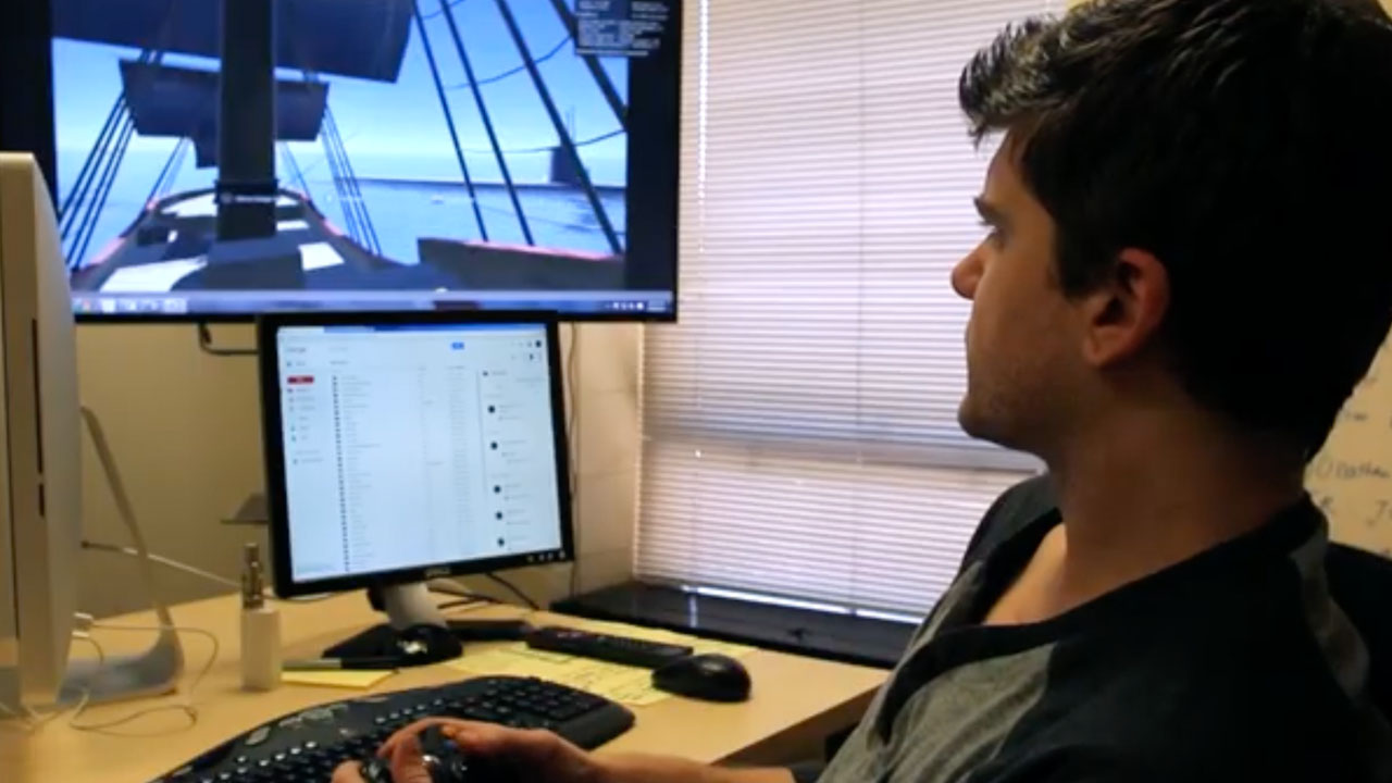 A student looks at a computer screen where he is playing a video game.