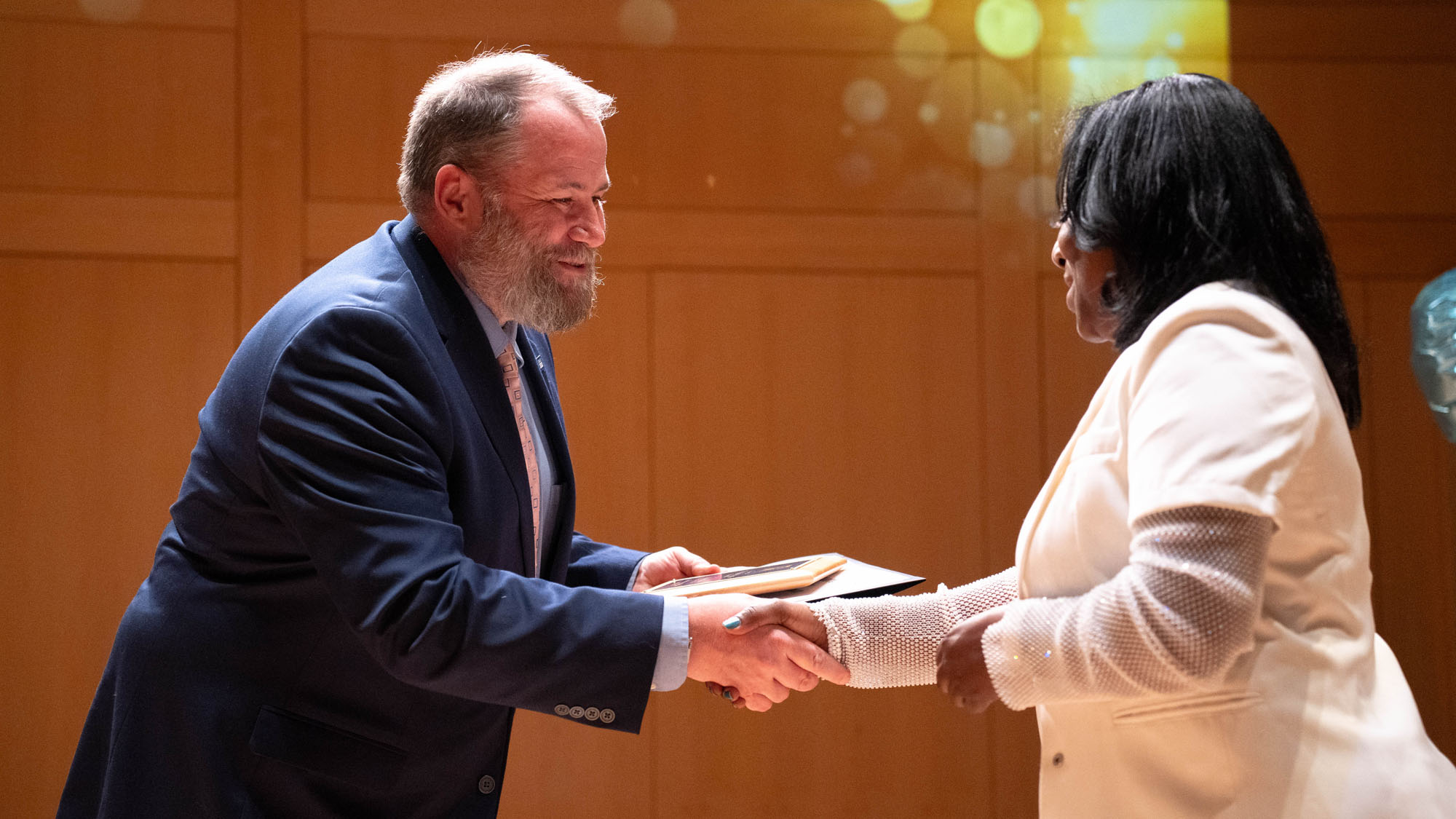 A presenter shakes hands with the winner