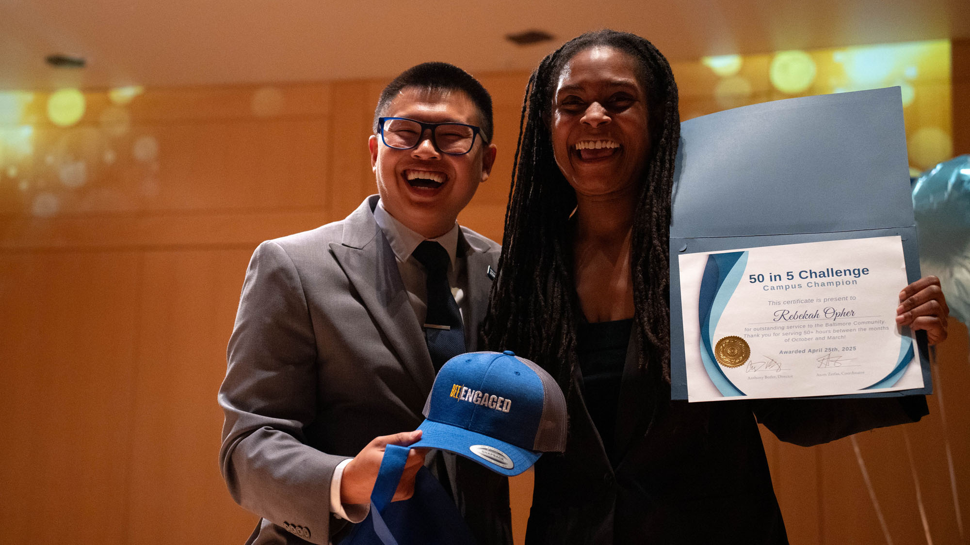 Both caught laughing, a presenter poses with the winning student